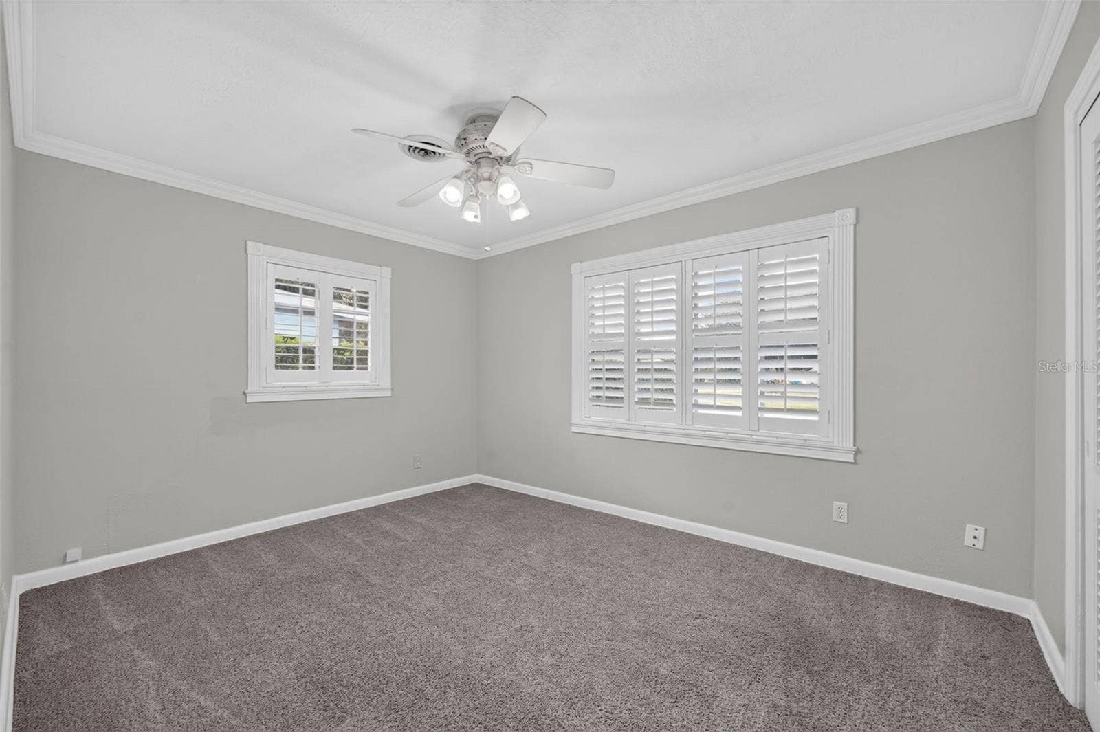 200 SENECA TRAIL, Maitland, FL 32751 Primary Bedroom Ample-sized primary bedroom positioned at the rear of the home with neutral carpeting, crown molding and custom interior shutters.