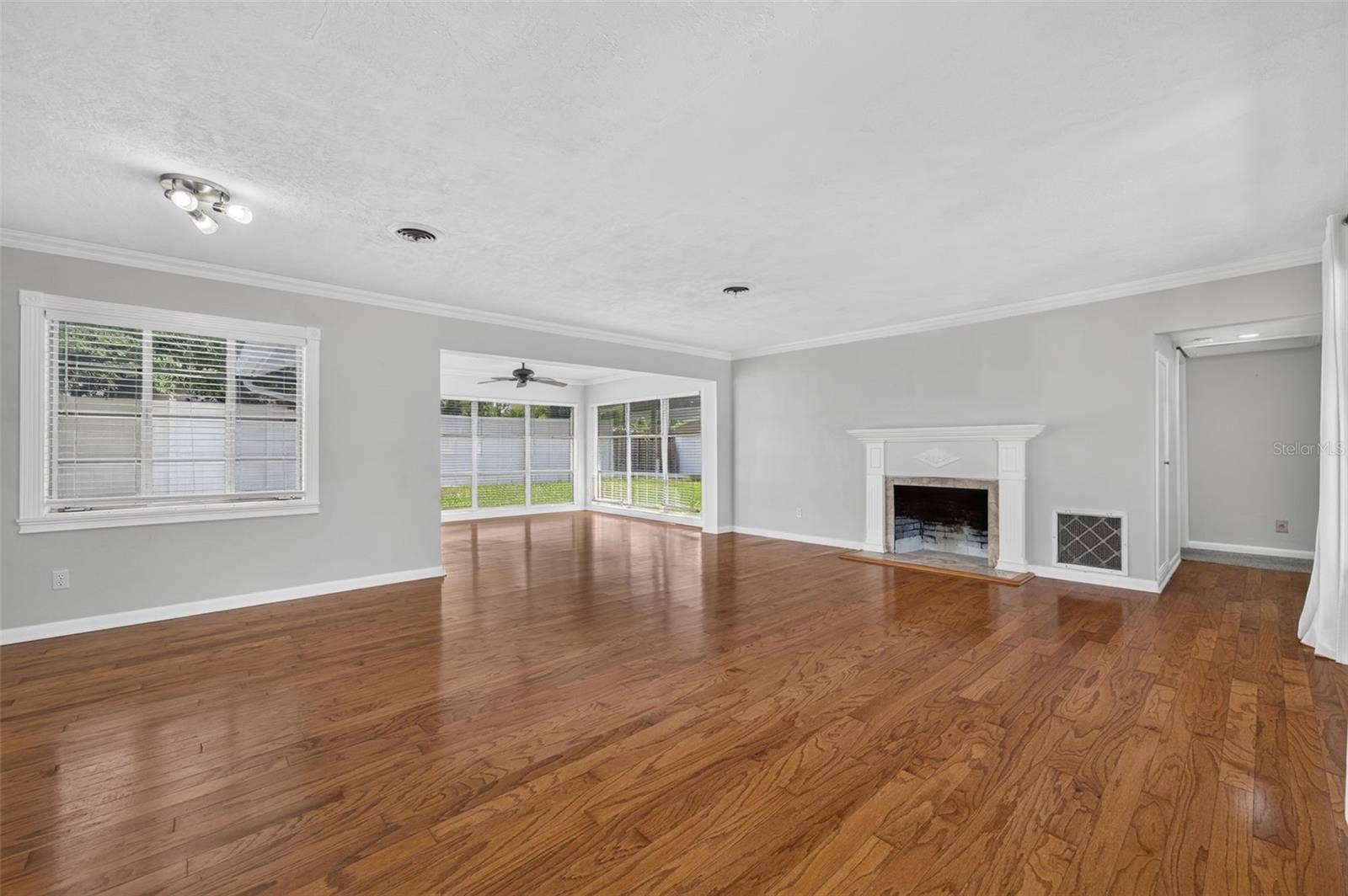 200 SENECA TRAIL, Maitland, FL 32751 Living & Dining Area Spacious combined living and dining area with hardwood floors, crown molding, fireplace, detailed millwork and abundant natural light from large-format windows.