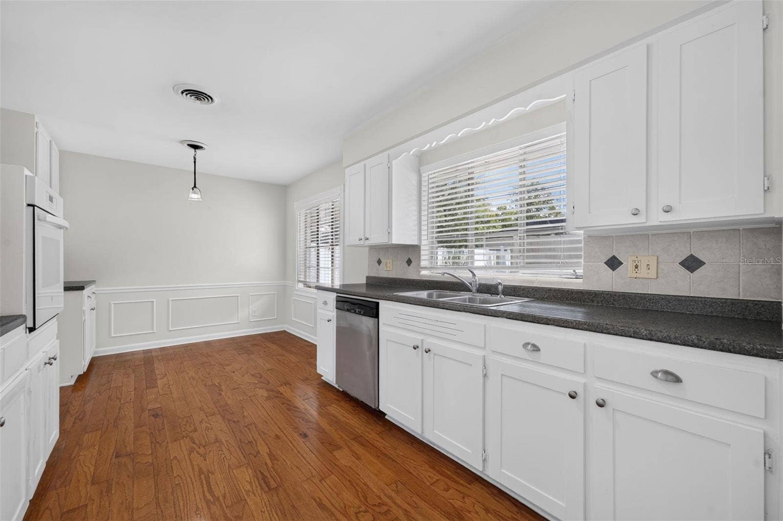 200 SENECA TRAIL, Maitland, FL 32751 Kitchen Charming kitchen retaining its original real-wood cabinetry, with a built-in oven, glass cooktop, stainless-steel dishwasher and hardwood flooring.