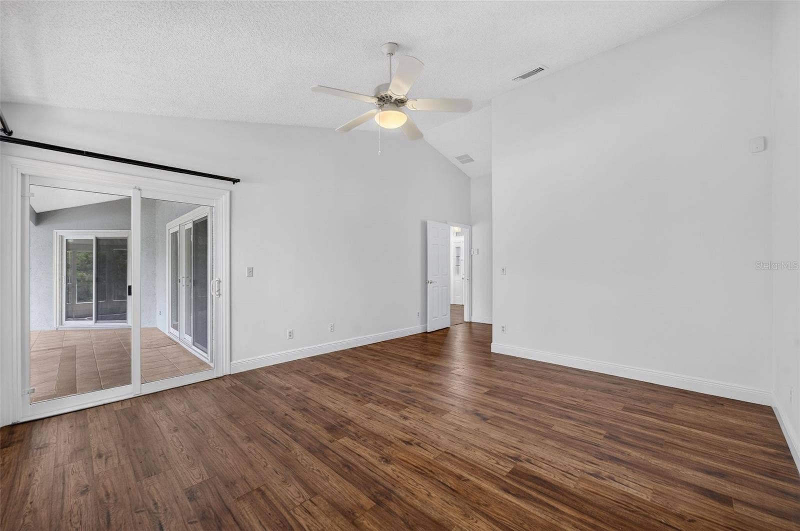 The spacious primary bedroom that opens to the large back patio and features beautiful lake views.