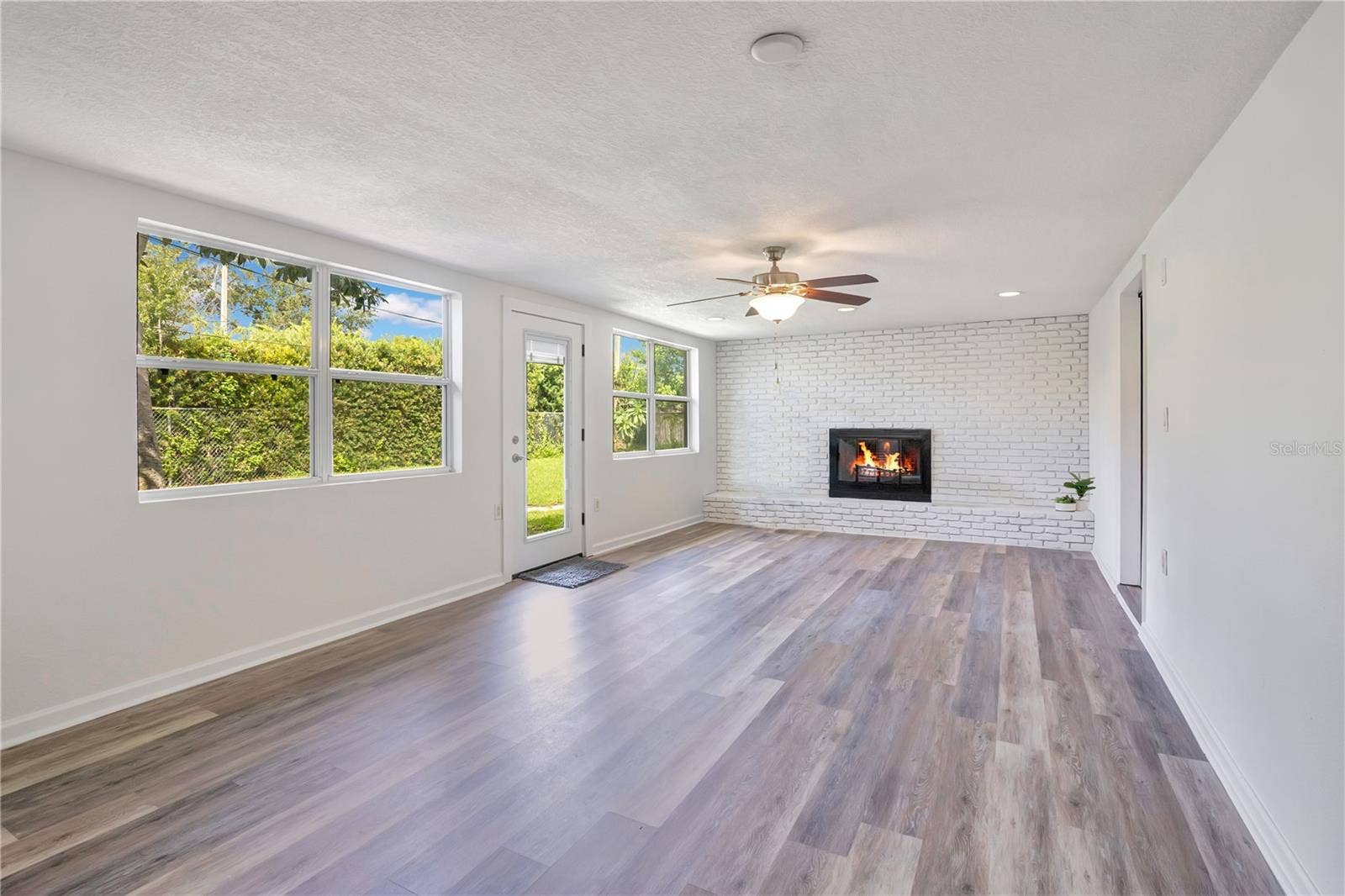 4415 HAYLOCK DRIVE, Orlando, FL 32807 Family Room with wood-burning fireplace leading to backyard