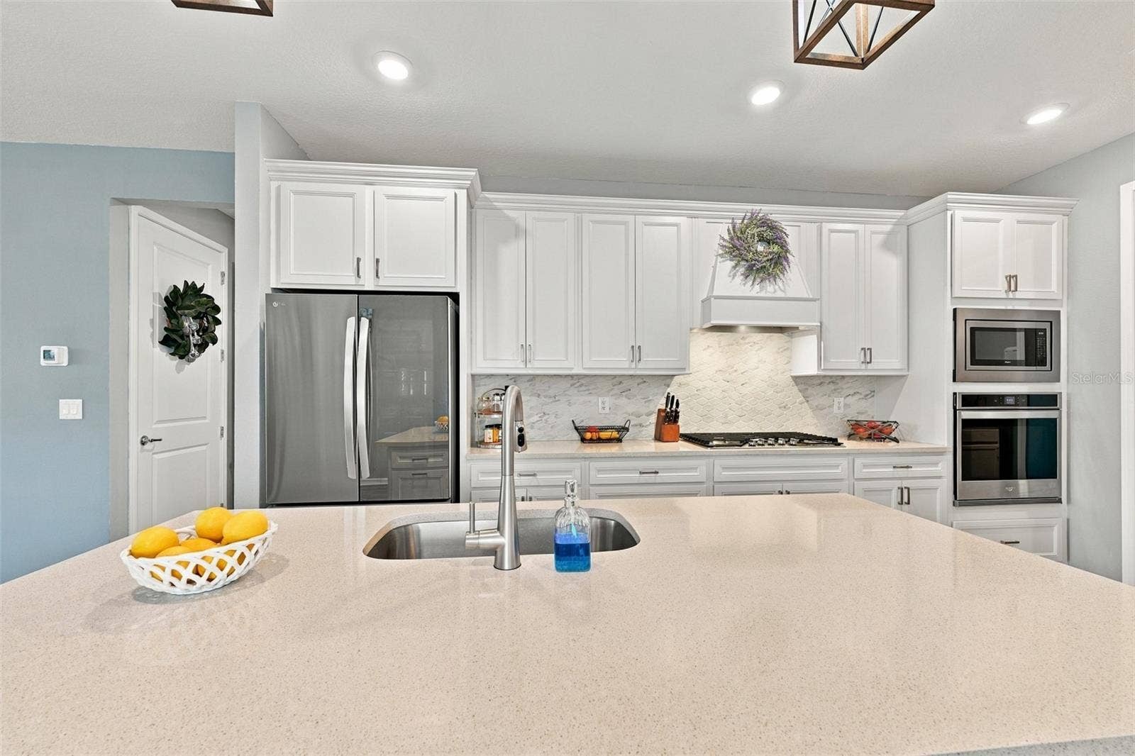 9260 BALLASTER POINTE LOOP, Parrish, FL 34219 Considerable Quartz countertops and decorater backsplash enhance this kitchen.