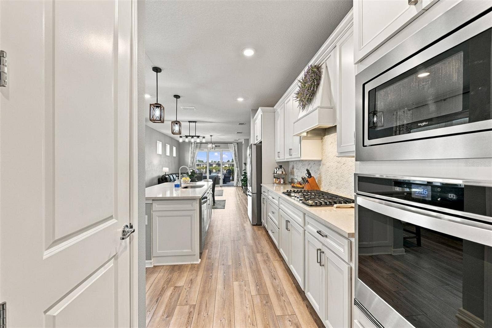 9260 BALLASTER POINTE LOOP, Parrish, FL 34219 Plenty of storage here, closet pantry and soft close cabnetry. Double Wall Oven and Gas Cooktop with Custom Vent Hood compliment this Luxury Kitchen.