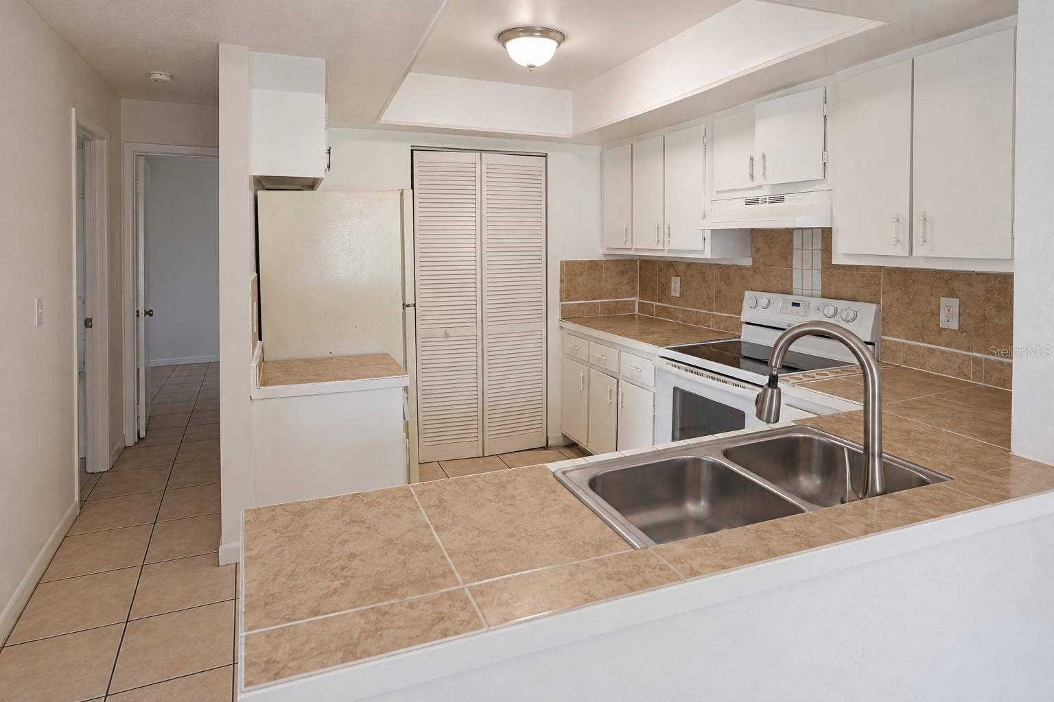 2527 CITRUS CLUB LANE, #3904, Orlando, FL 32839 Kitchen with pantry and opening from dining area. Bedrooms at left.