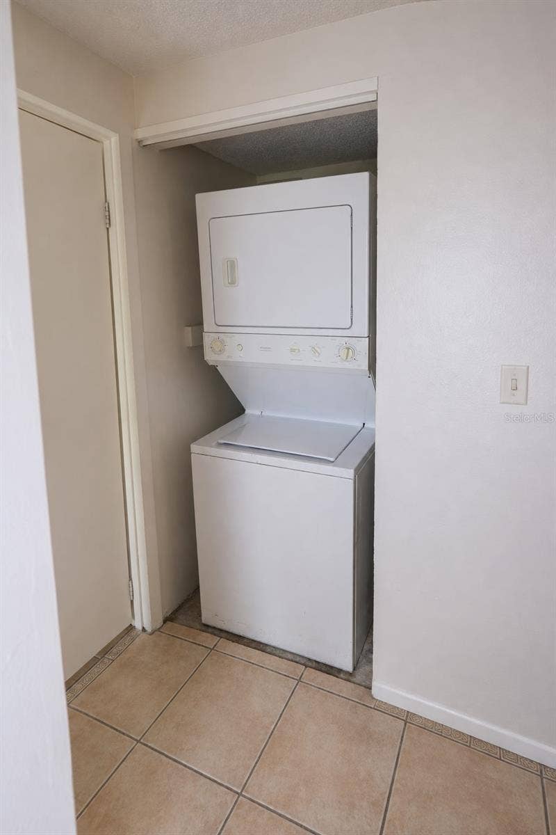 2527 CITRUS CLUB LANE, #3904, Orlando, FL 32839 Stacked washer and dryer in laundry closet.