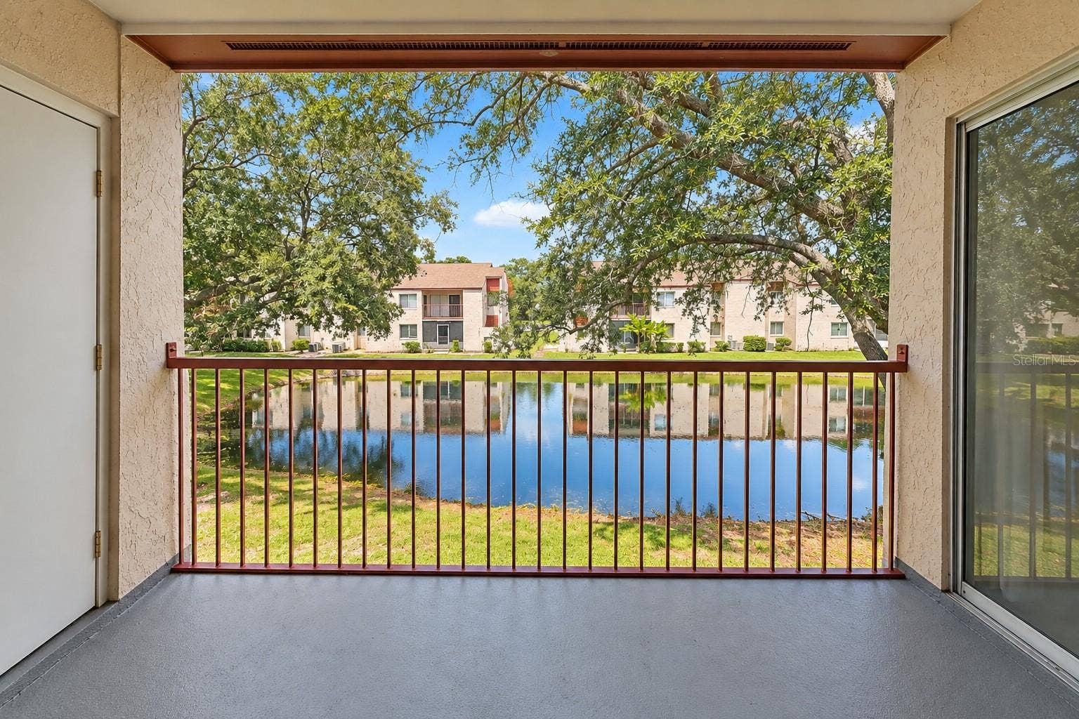2527 CITRUS CLUB LANE, #3904, Orlando, FL 32839 Tranquil pond view from balcony. Exterior storage room at left.