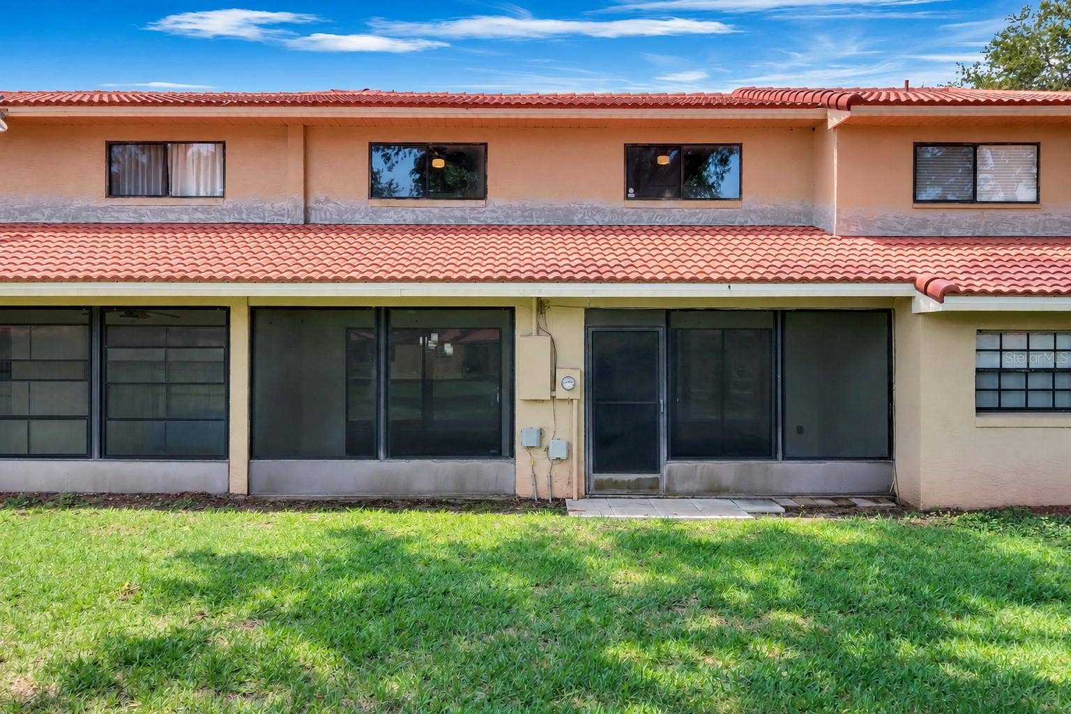 8235 AMBROSE COVE WAY, Orlando, FL 32819 Screened lanai opens onto a shared green space.