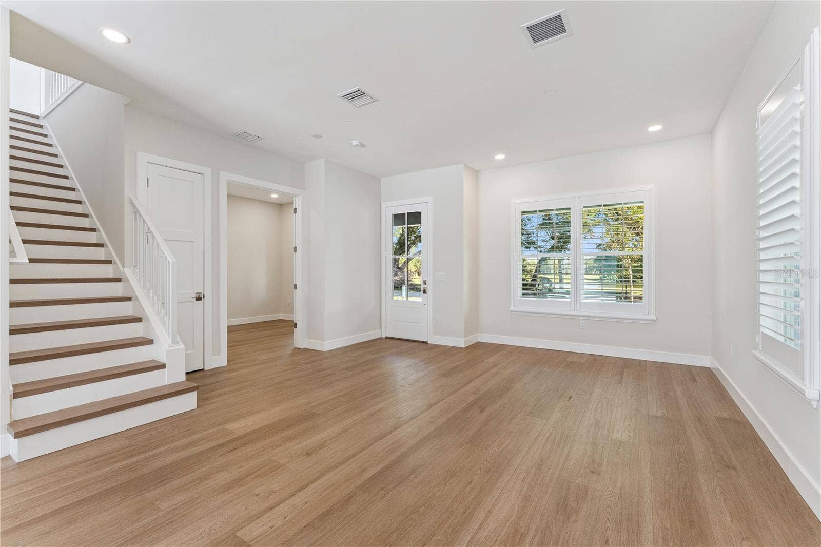 3456 FAIRWAY LANE, Orlando, FL 32804 The front room offers natural light, recessed lighting, and a view of the staircase.