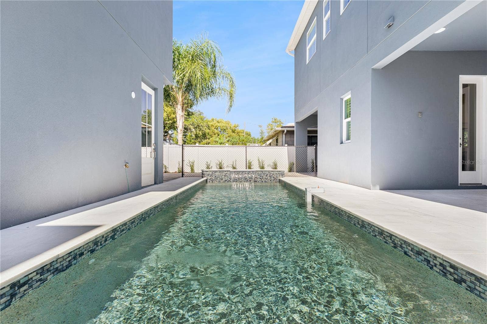 3456 FAIRWAY LANE, Orlando, FL 32804 A lengthwise pool view shows the surrounding paved deck and the relationship to the home.