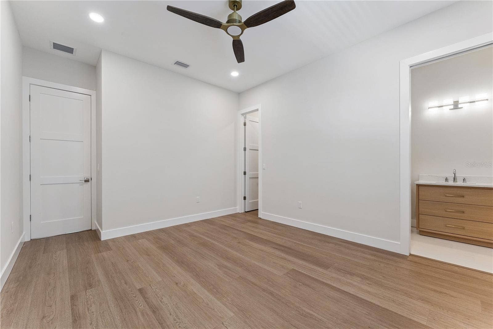 3456 FAIRWAY LANE, Orlando, FL 32804 This bedroom includes a shuttered window, ceiling fan, and a view into the built-in closet.