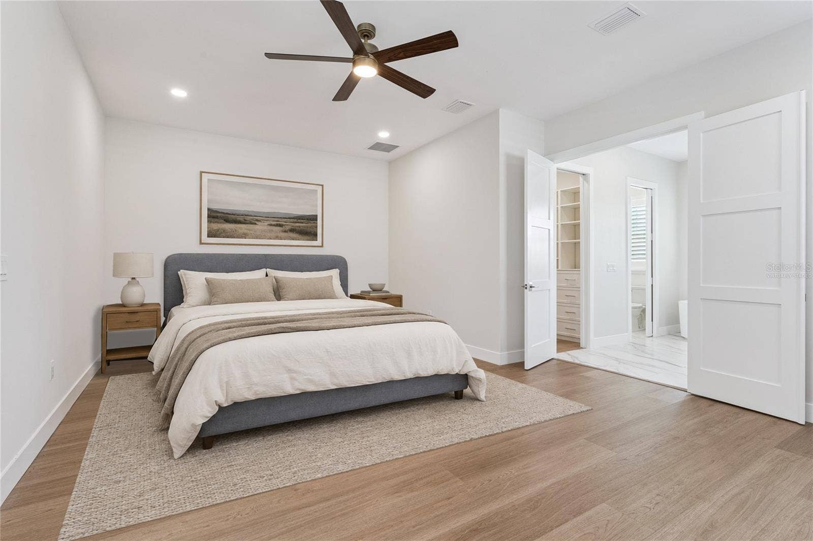 3456 FAIRWAY LANE, Orlando, FL 32804 Virtually Staged - The primary bedroom features a ceiling fan and a view toward the adjoining bathroom.
