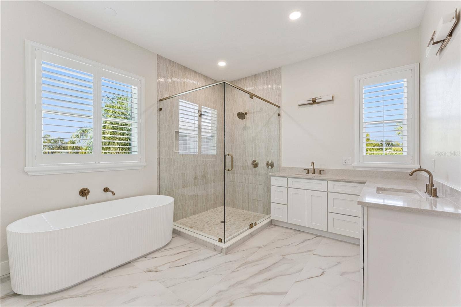 3456 FAIRWAY LANE, Orlando, FL 32804 A freestanding tub, glass-enclosed shower, and two sinks define this spacious bathroom.
