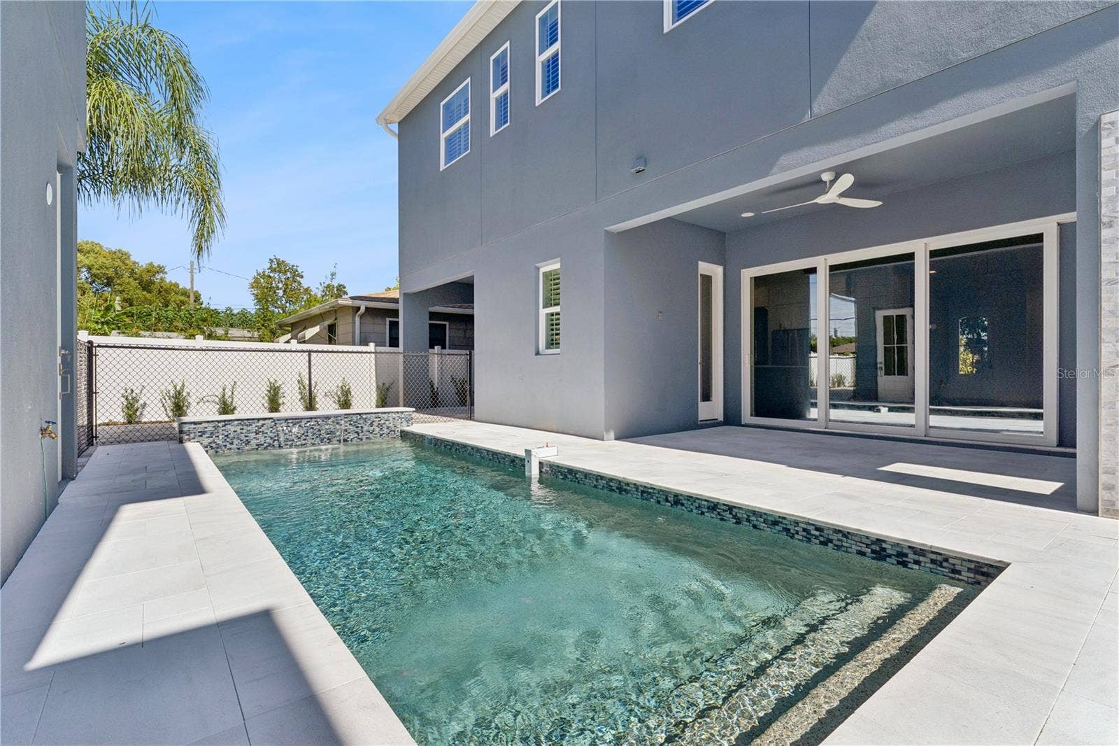 3456 FAIRWAY LANE, Orlando, FL 32804 The pool sits beside a paved deck and covered rear patio, creating an inviting outdoor setting.