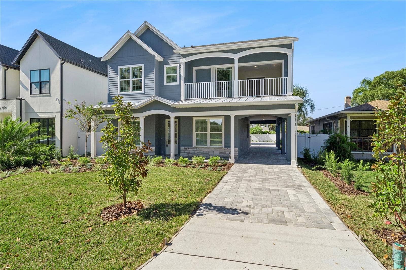 3456 FAIRWAY LANE, Orlando, FL 32804 A driveway-side view shows the home's front porch, balcony, and covered side passage.