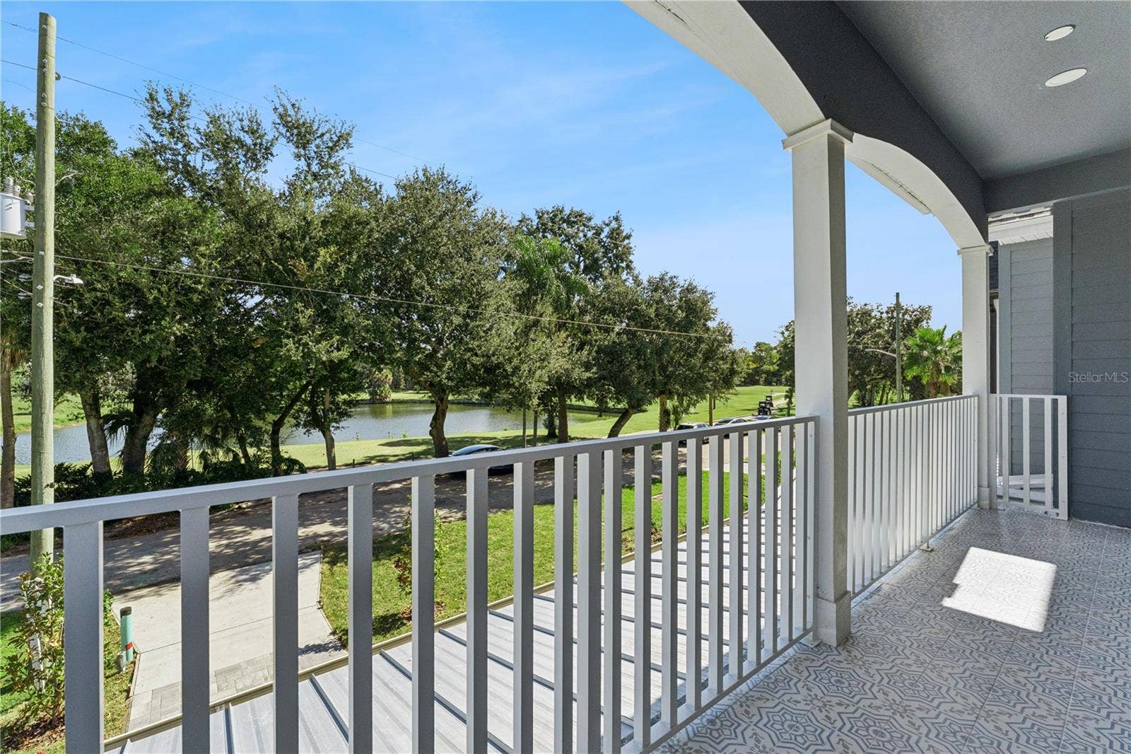 3456 FAIRWAY LANE, Orlando, FL 32804 The covered front balcony offers an elevated outlook toward the golf course and surrounding trees.