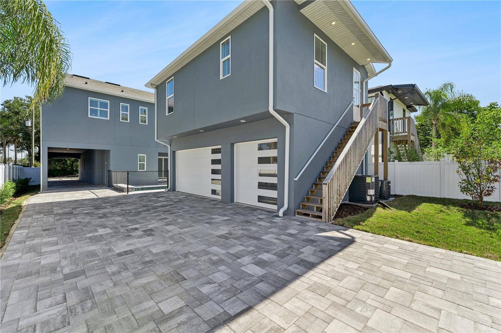 3456 FAIRWAY LANE, Orlando, FL 32804 The rear garage has two garage doors, an exterior staircase, and a paved parking area.