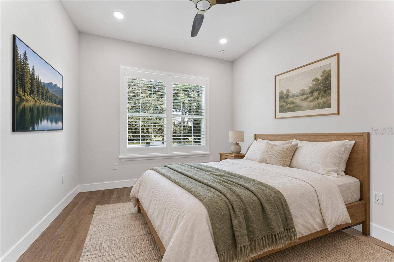 3456 FAIRWAY LANE, Orlando, FL 32804 Virtually Staged - A shuttered window, ceiling fan, and light walls create a bright bedroom setting.