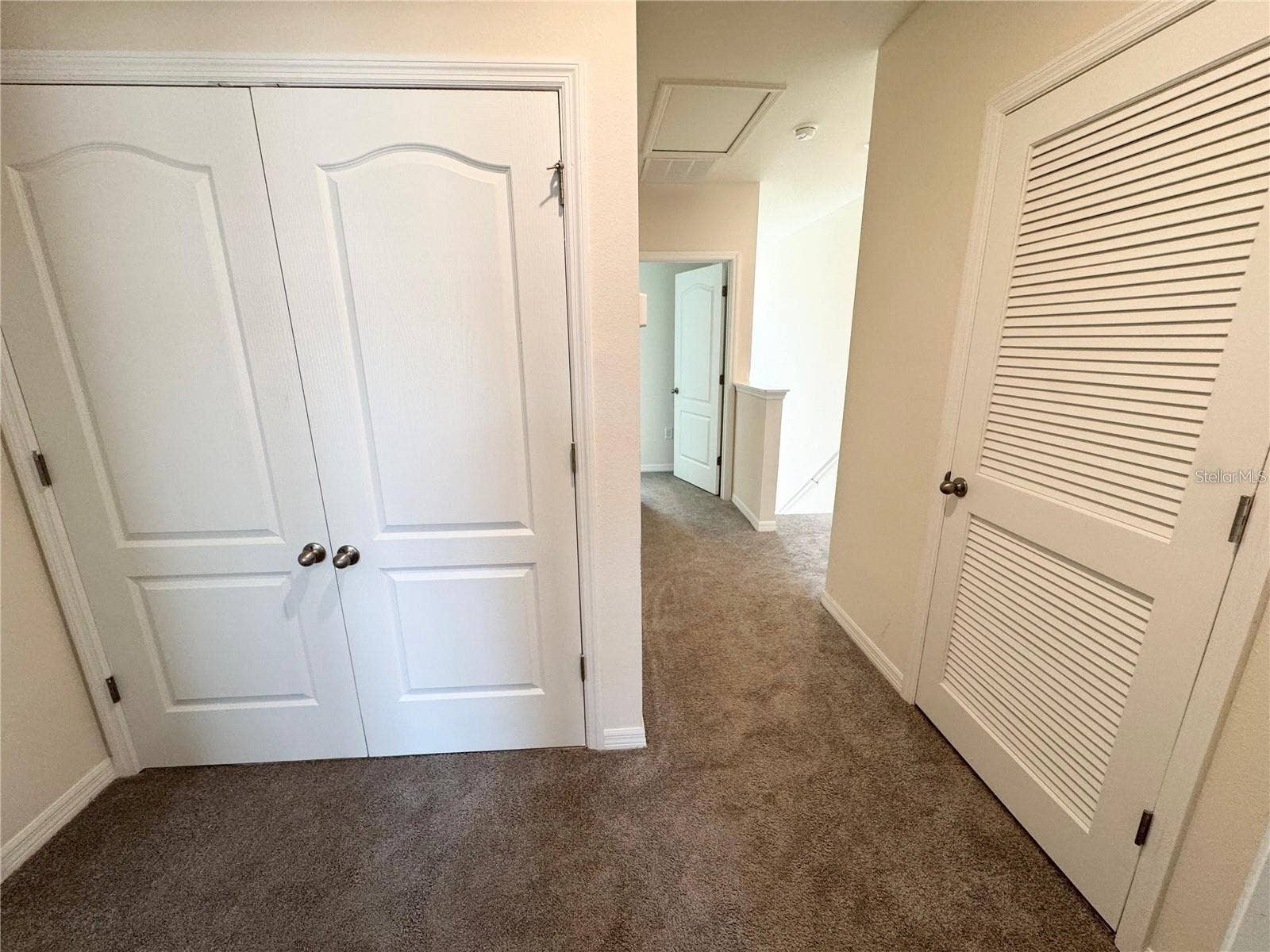 View of second story, enclosed laundry room and primary bedroom entrance.