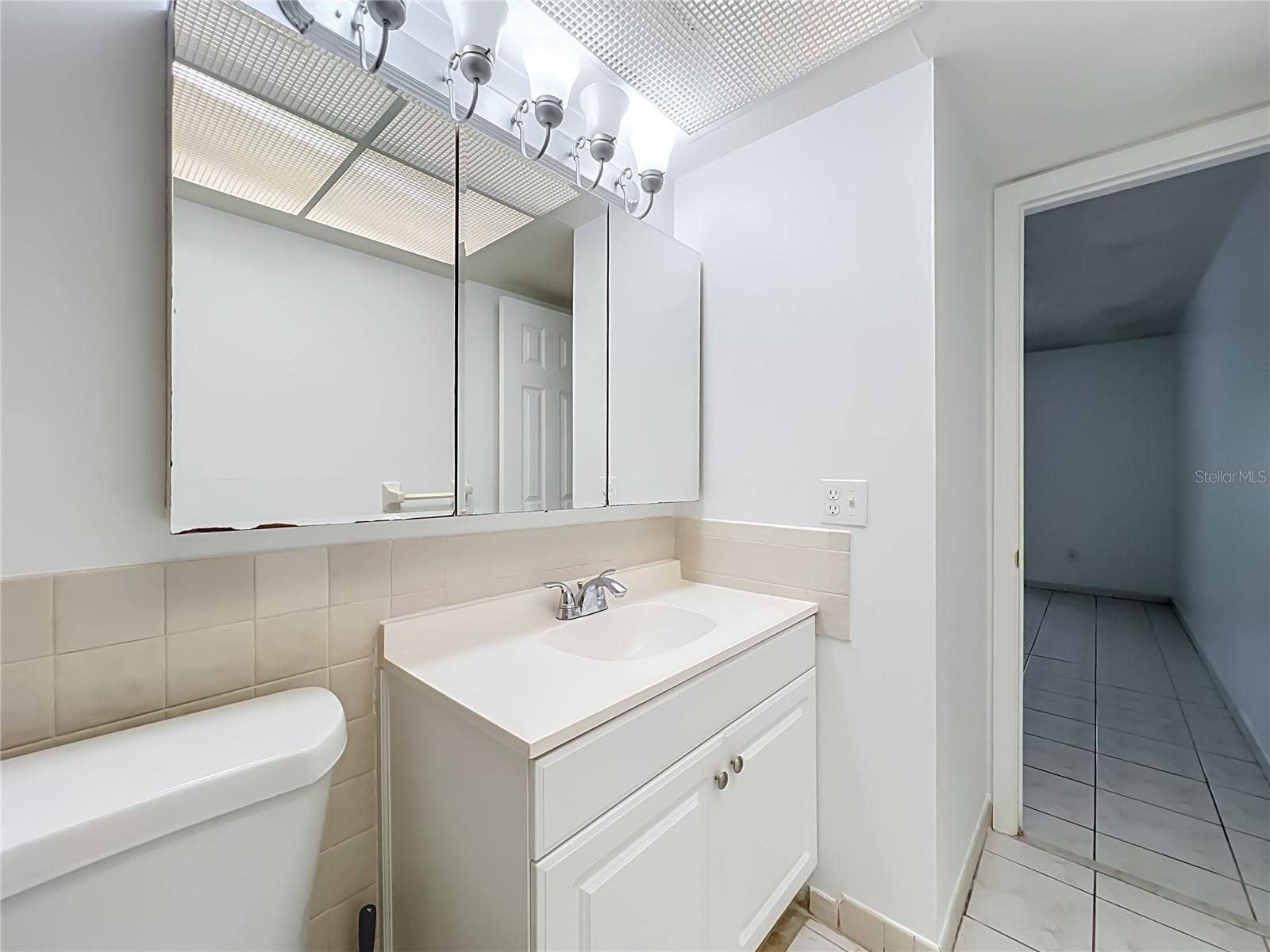 1225 CARRIAGE LANE, #1, Orlando, FL 32807 Bright vanity area with mirrored medicine cabinet and additional storage.