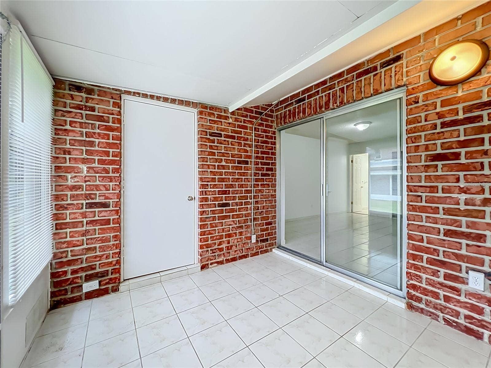 1225 CARRIAGE LANE, #1, Orlando, FL 32807 Exposed brick brings warmth and character to the spacious Florida room.