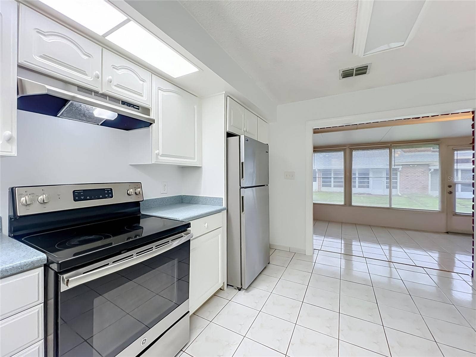 1225 CARRIAGE LANE, #1, Orlando, FL 32807 Bright kitchen with white cabinetry, ample storage and included appliances.