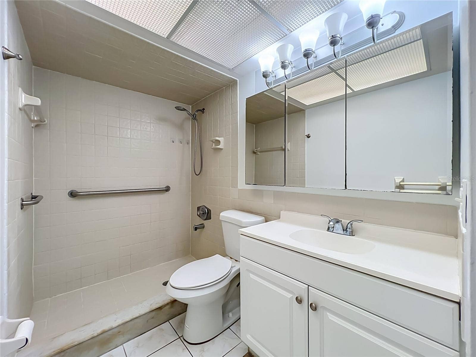 1225 CARRIAGE LANE, #1, Orlando, FL 32807 Primary bathroom with shower and generous vanity storage.
