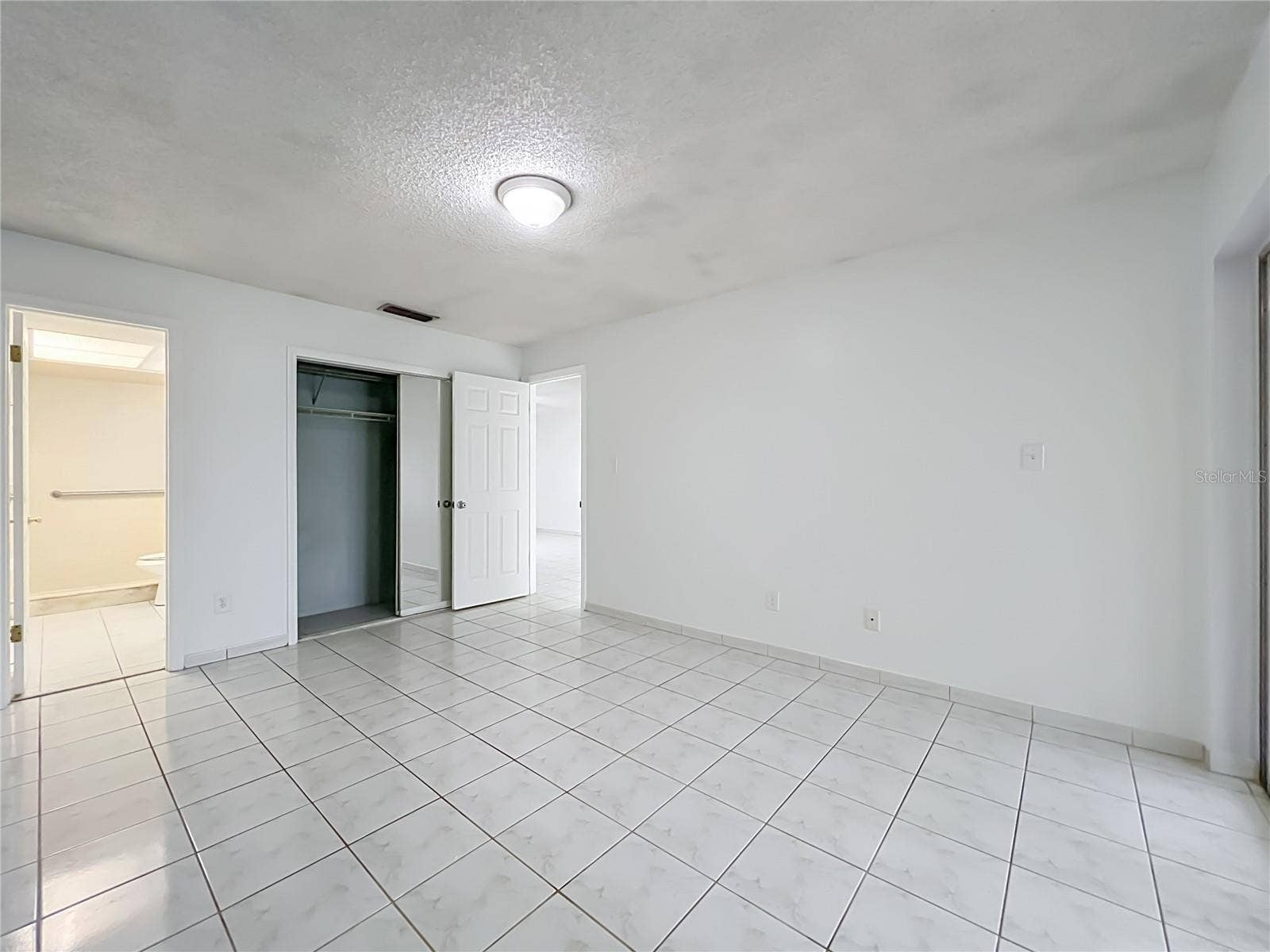 1225 CARRIAGE LANE, #1, Orlando, FL 32807 Spacious primary bedroom with ceramic tile flooring and plenty of room to make it your own.