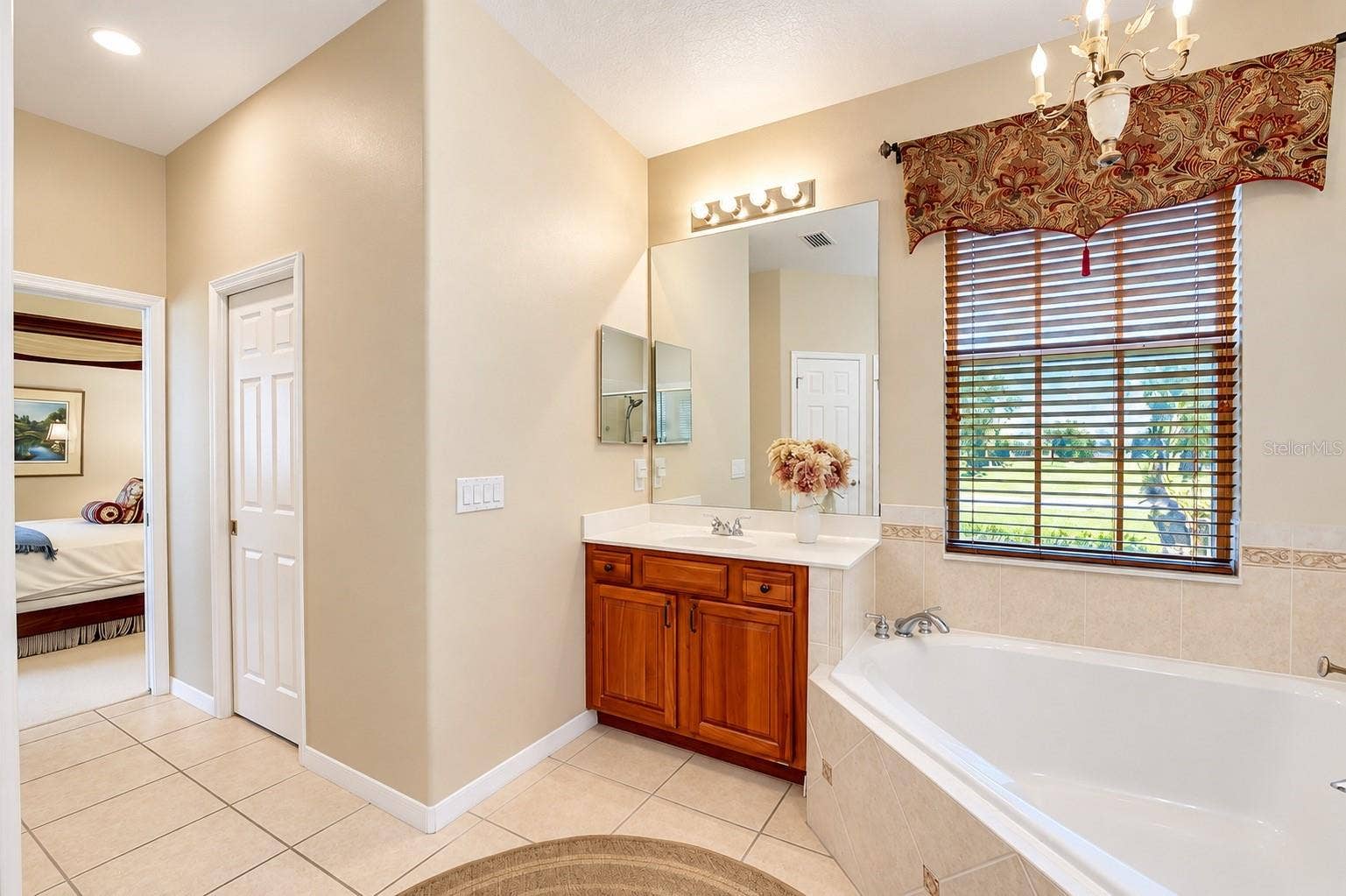 DUAL VANITIES WITH RICH WOOD CABINETRY, A LARGE SOAKING GARDEN TUB, AND A SEPARATE WALK-IN SHOWER WITH CUSTOM TILEWORK AND GLASS ENCLOSURE!