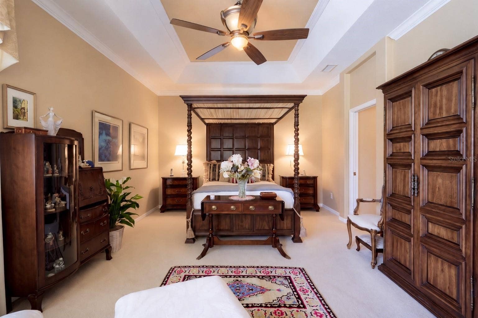 STUNNING OVERSIZED PRIMARY BEDROOM FEATURING SOARING CEILINGS, AN EXPANSIVE PRIVATE SITTING AREA, AND BEAUTIFUL VIEWS OF THE SPARKLING POOL AND LUSH OUTDOOR SURROUNDINGS!