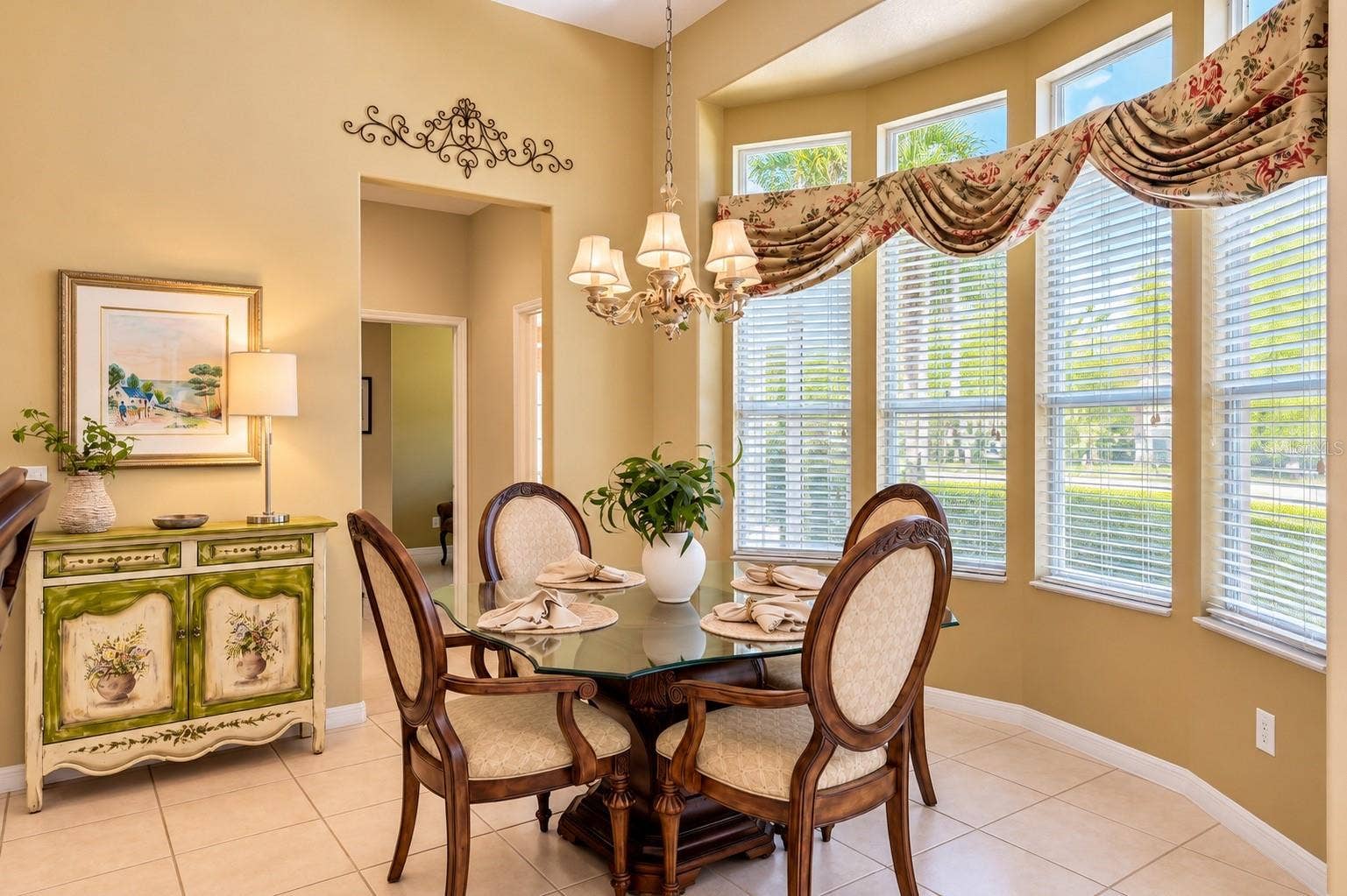 CHARMING BREAKFAST NOOK FEATURING SOARING CEILINGS, ELEGANT LIGHTING, AND A BEAUTIFUL CURVED WALL OF WINDOWS THAT FILLS THE SPACE WITH NATURAL LIGHT! Enjoy peaceful mornings with your favorite cup of coffee while overlooking the lush outdoor landscaping. The perfect setting for casual dining and everyday gatherings!