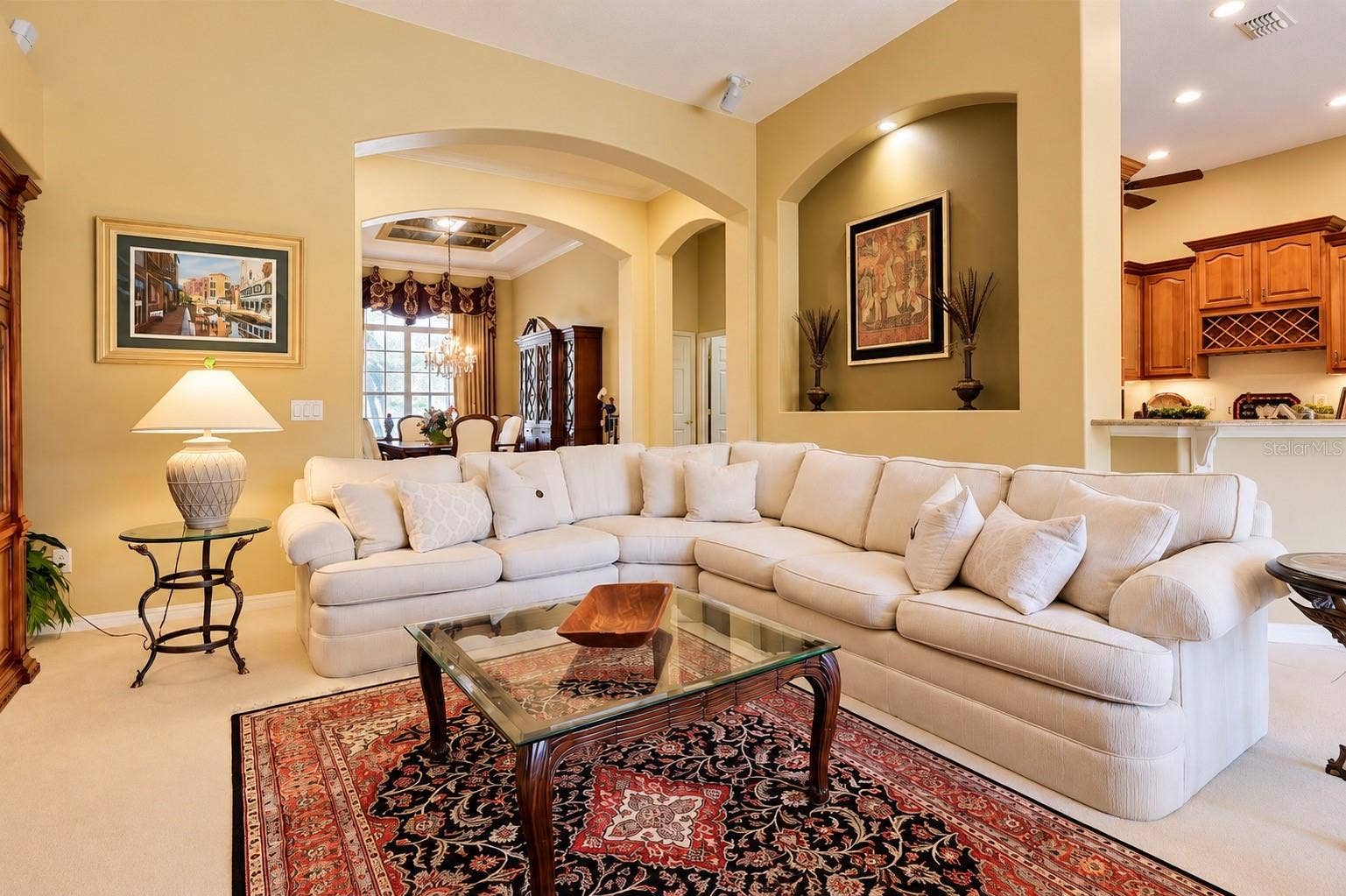 SPACIOUS AND INVITING FAMILY ROOM FEATURING SOARING CEILINGS, BEAUTIFUL ARCHITECTURAL ARCHWAYS, CUSTOM DECORATIVE WALL NICHE WITH ACCENT LIGHTING, AND AN OPEN-CONCEPT DESIGN!