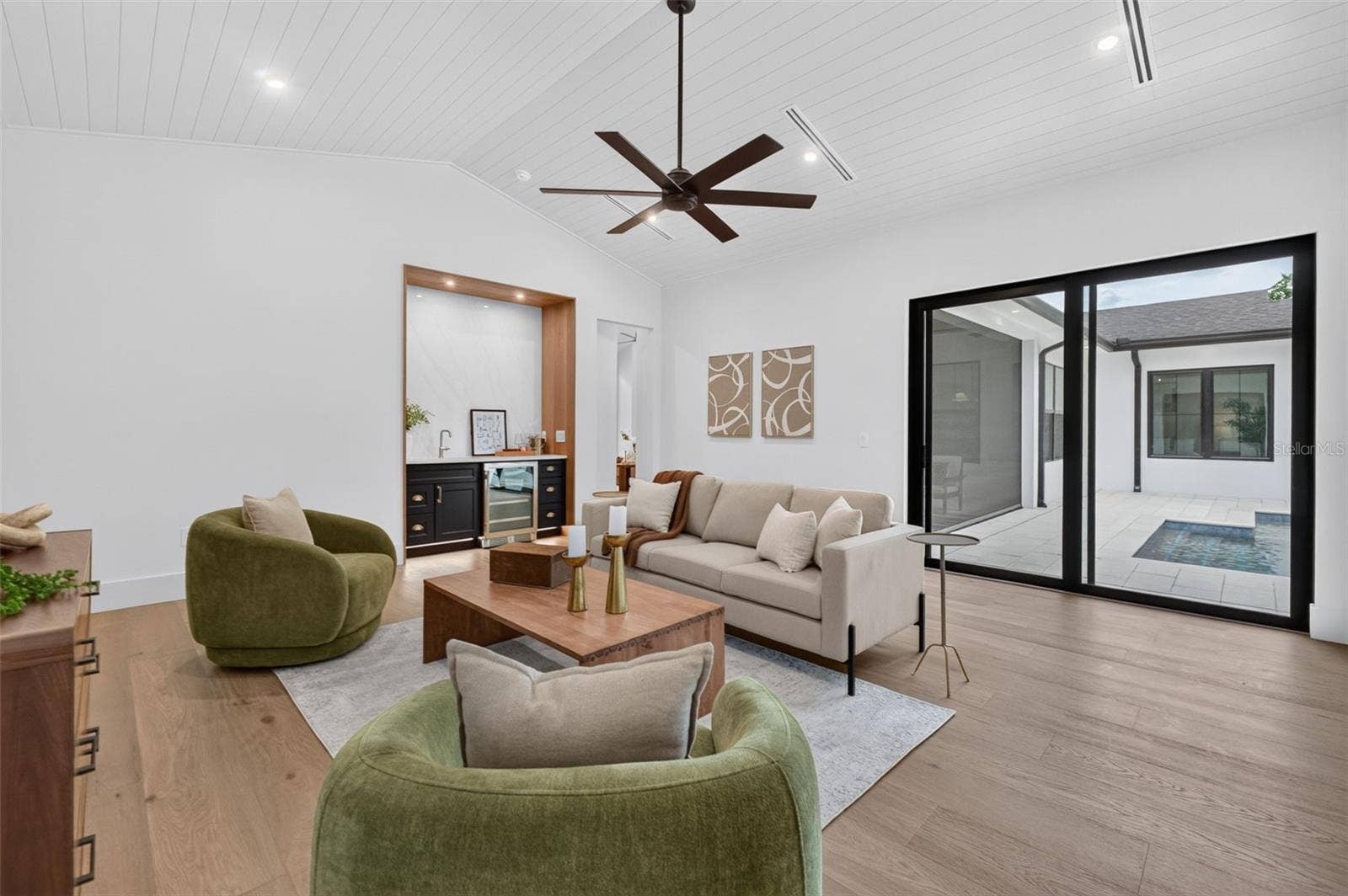1815 WINDERMERE ROAD, Windermere, FL 34786 Game room features a wet bar with beverage refrigerator and two large sliding glass doors that provide direct access to pool and covered lanai