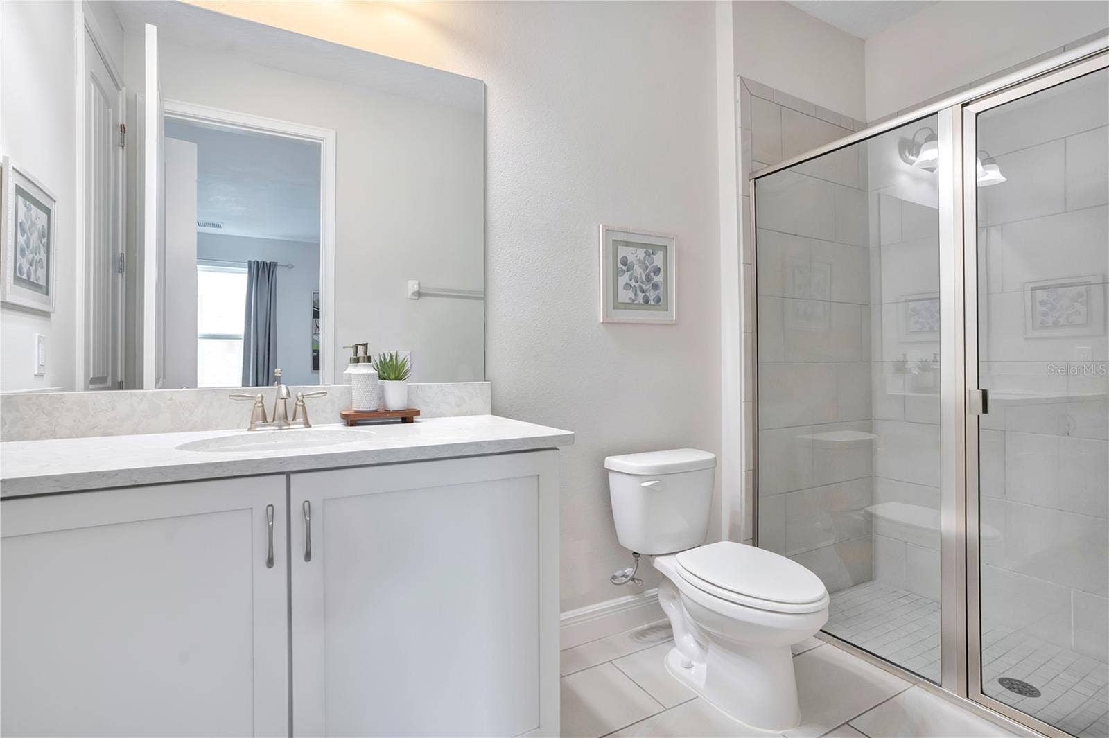 7704 WESTLAND DRIVE, Kissimmee, FL 34747 Private en-suite bath featuring a contemporary vanity and glass-enclosed shower