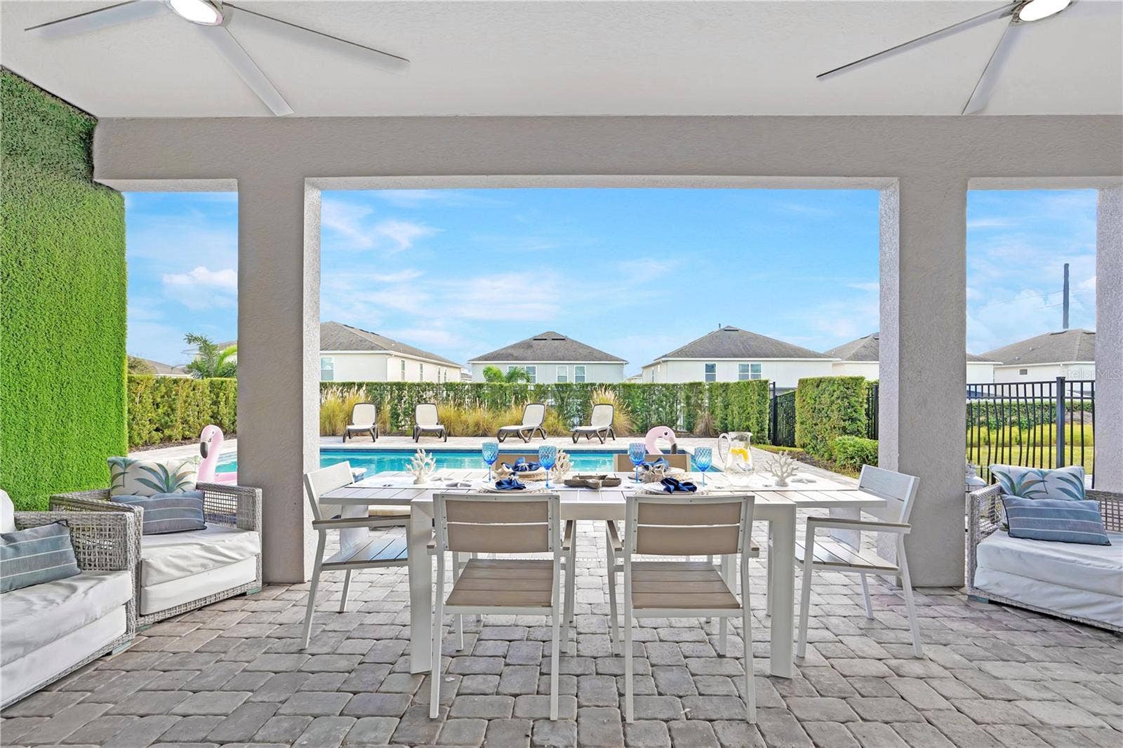 7704 WESTLAND DRIVE, Kissimmee, FL 34747 Covered outdoor dining overlooking the private pool and tropical landscaping
