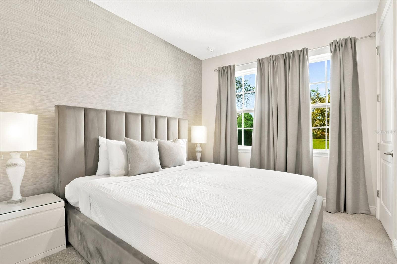 7704 WESTLAND DRIVE, Kissimmee, FL 34747 A serene guest suite with elegant furnishings, soft neutral tones, and beautiful natural light