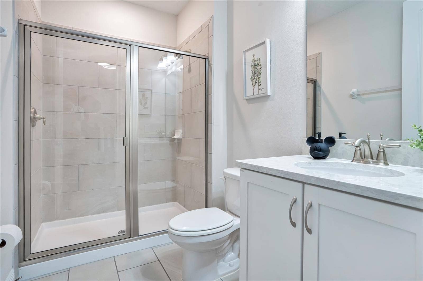 7704 WESTLAND DRIVE, Kissimmee, FL 34747 Private en-suite bath to Mickey & Minnie's Hideaway - with glass-enclosed shower and contemporary finishes