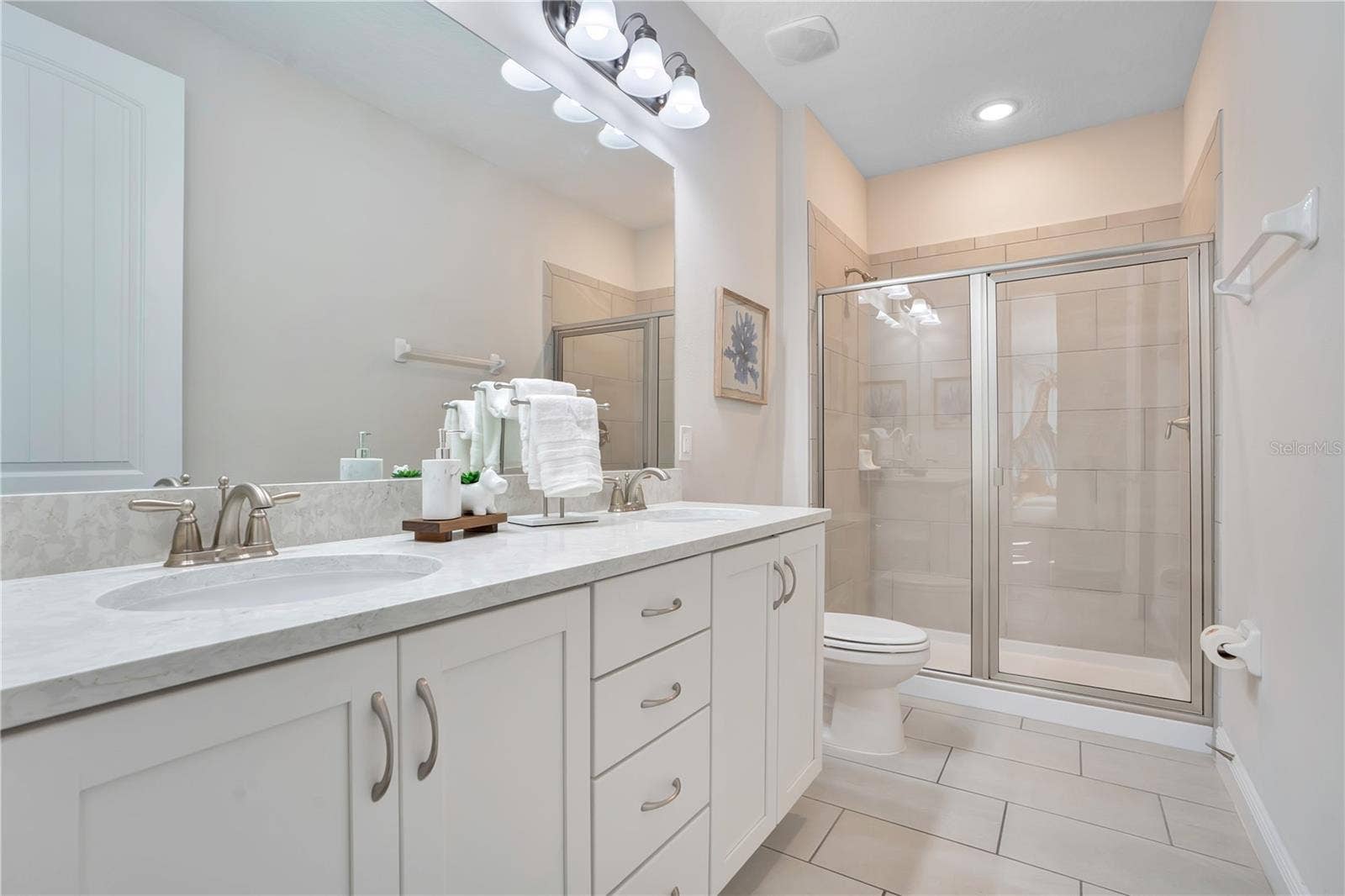 7704 WESTLAND DRIVE, Kissimmee, FL 34747 A beautifully finished bath with generous counter space and a glass-enclosed shower -