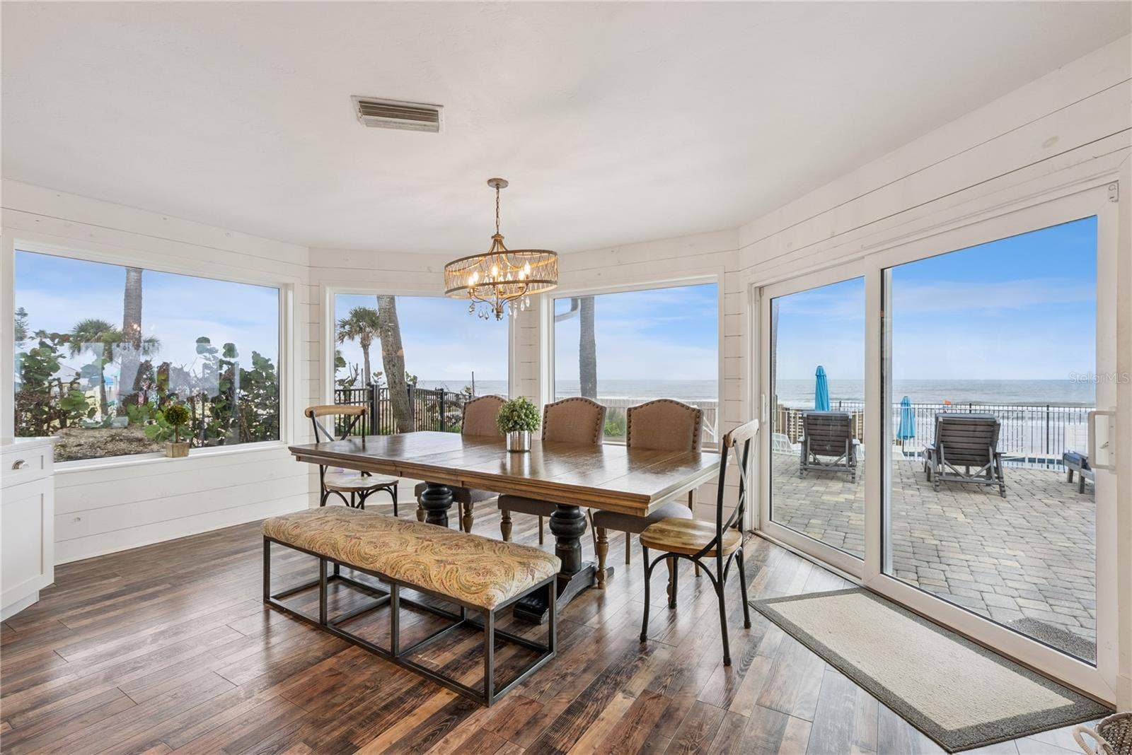 Spacious eat-in kitchen with stainless steel appliances, quartz countertops, breakfast bar seating, and beautiful ocean viewsan inviting setting for casual meals and gathering.