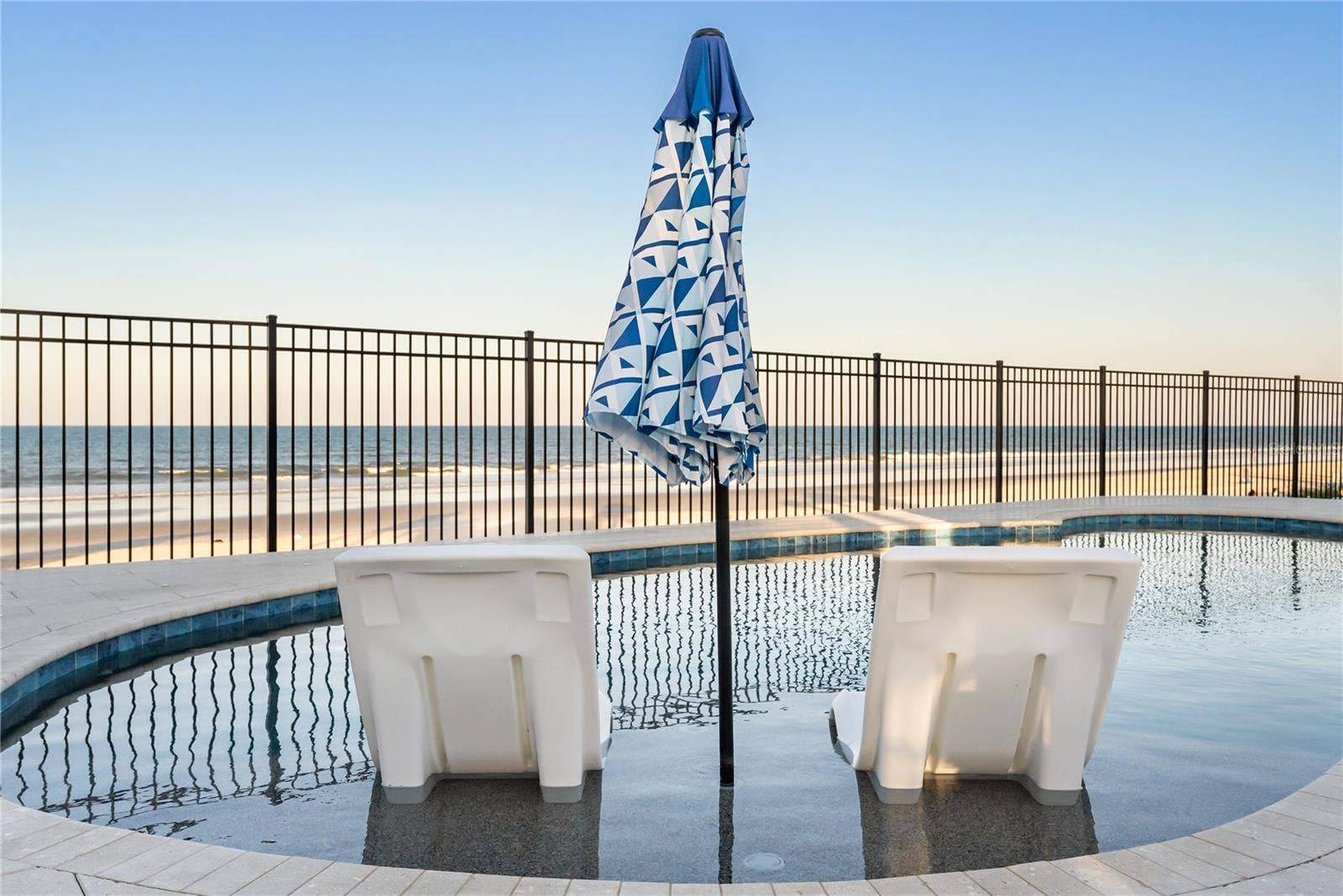 new poolNew oceanfront pool installed in 2024, featuring heating, a sun shelf, bubblers, and a 7-foot-deep end, with expansive patio space and panoramic Atlantic views.