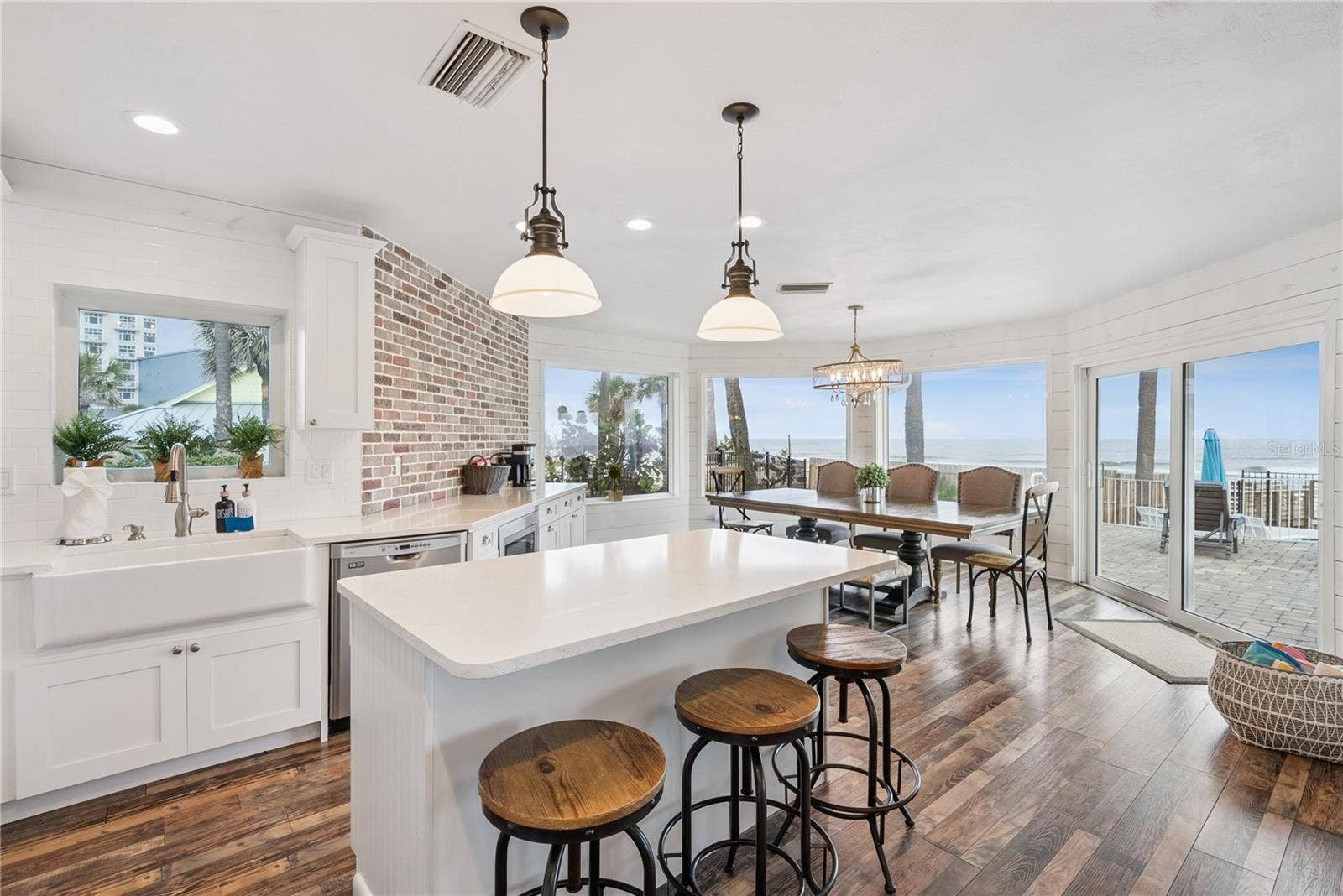 Spacious eat-in kitchen with stainless steel appliances, quartz countertops, breakfast bar seating, and beautiful ocean viewsan inviting setting for casual meals and gathering.