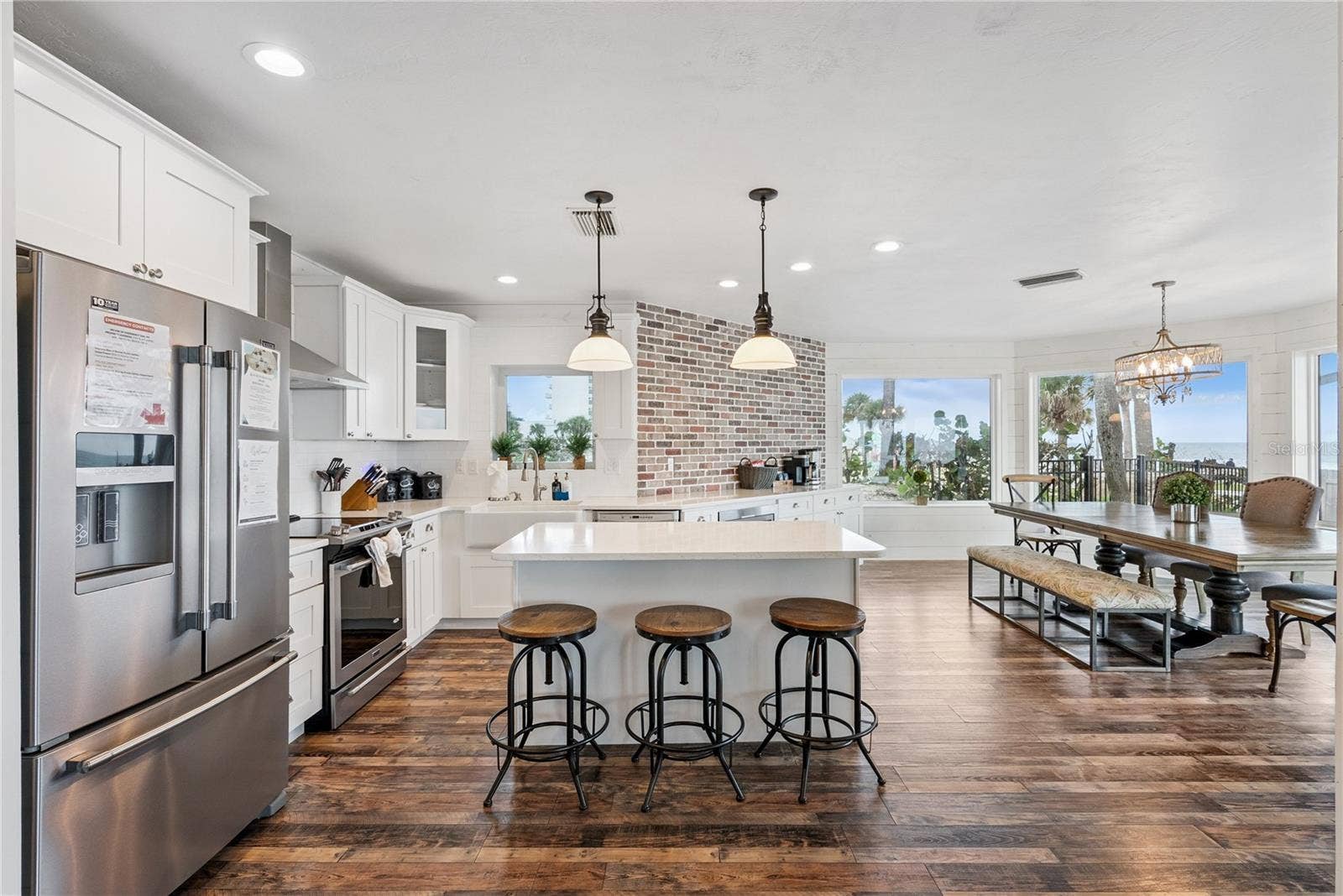 Spacious eat-in kitchen with stainless steel appliances, quartz countertops, breakfast bar seating, and beautiful ocean viewsan inviting setting for casual meals and gathering.