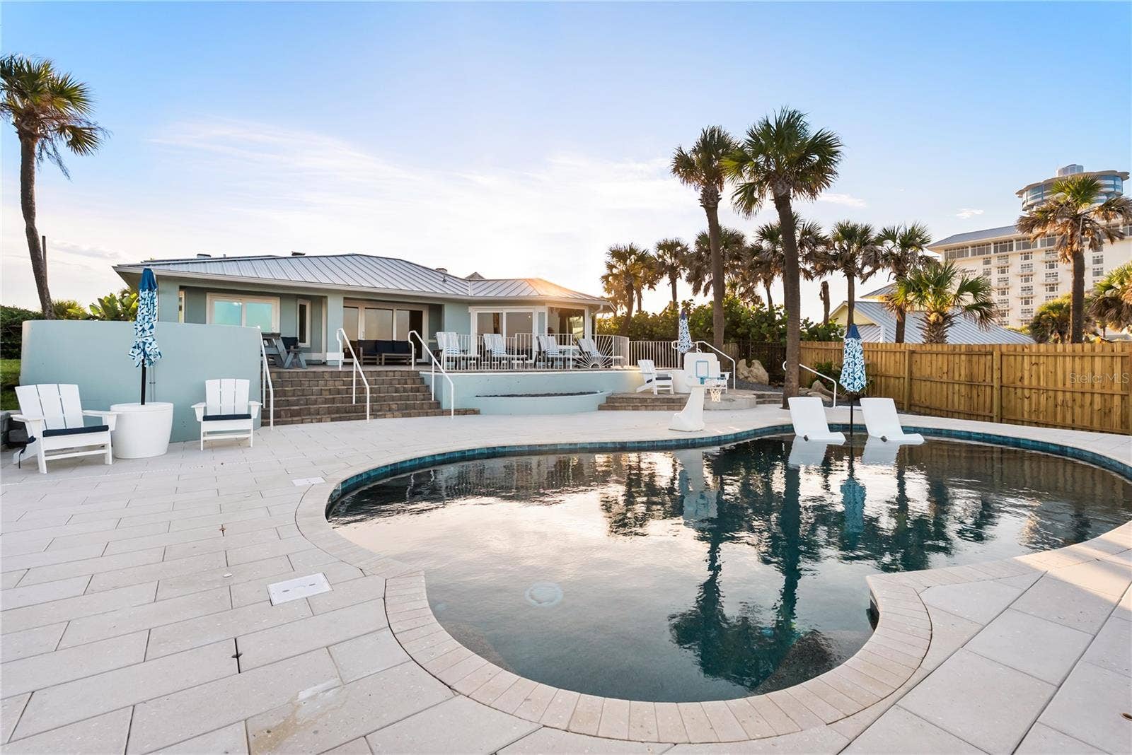 New oceanfront pool installed in 2024, featuring heating, a sun shelf, bubblers, and a 7-foot-deep end, with expansive patio space and panoramic Atlantic views