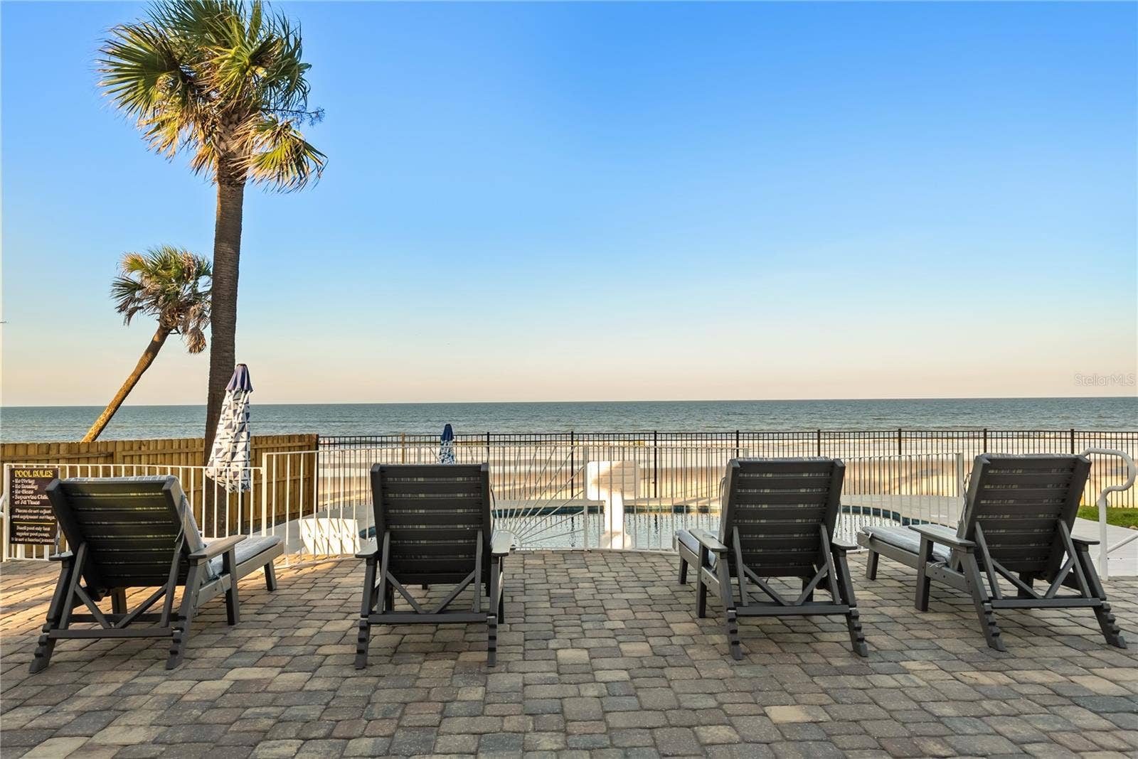 new poolNew oceanfront pool installed in 2024, featuring heating, a sun shelf, bubblers, and a 7-foot-deep end, with expansive patio space and panoramic Atlantic views.