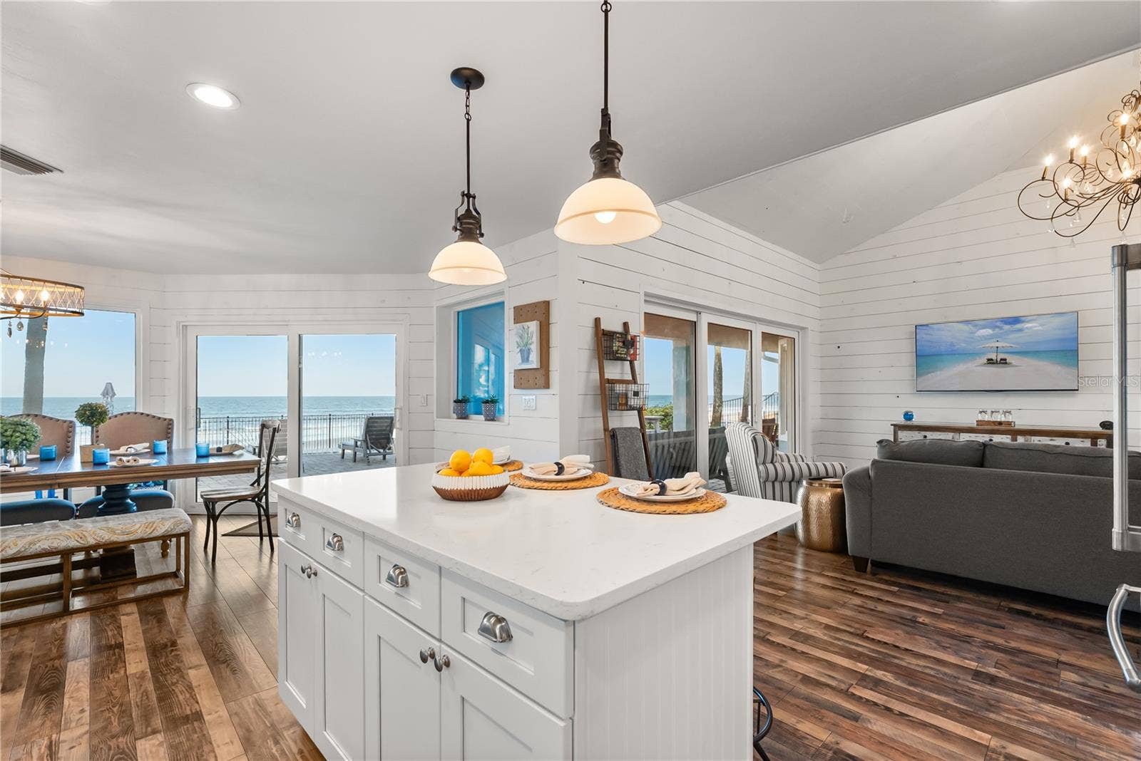 Spacious eat-in kitchen with stainless steel appliances, quartz countertops, breakfast bar seating, and beautiful ocean viewsan inviting setting for casual meals and gathering.