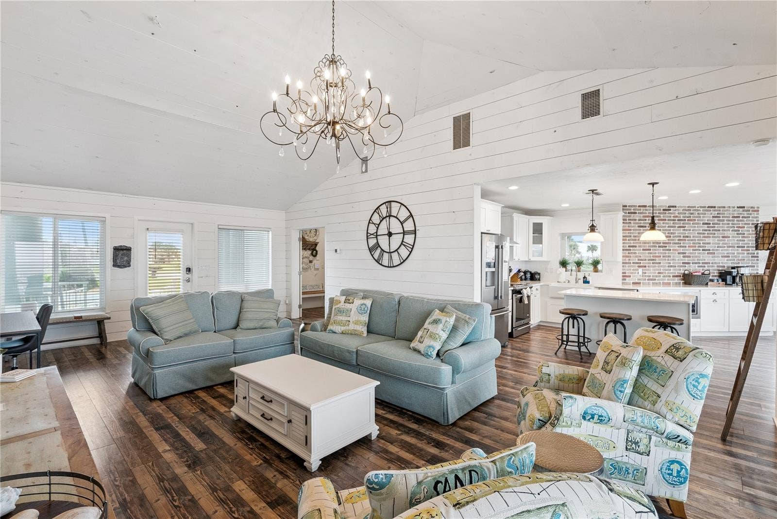 Sweeping Atlantic views take center stage in this bright family room, complemented by coastal furnishings and luxury vinyl plank flooring.