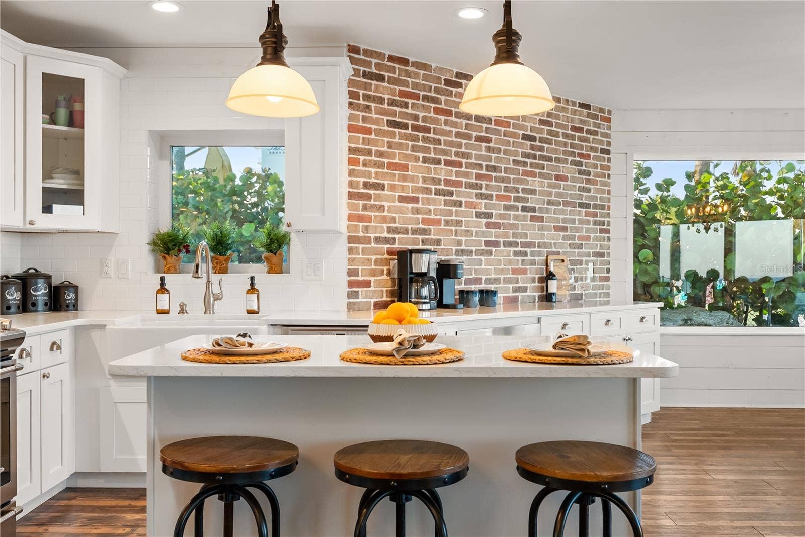 Spacious eat-in kitchen with stainless steel appliances, quartz countertops, breakfast bar seating, and beautiful ocean viewsan inviting setting for casual meals and gathering.