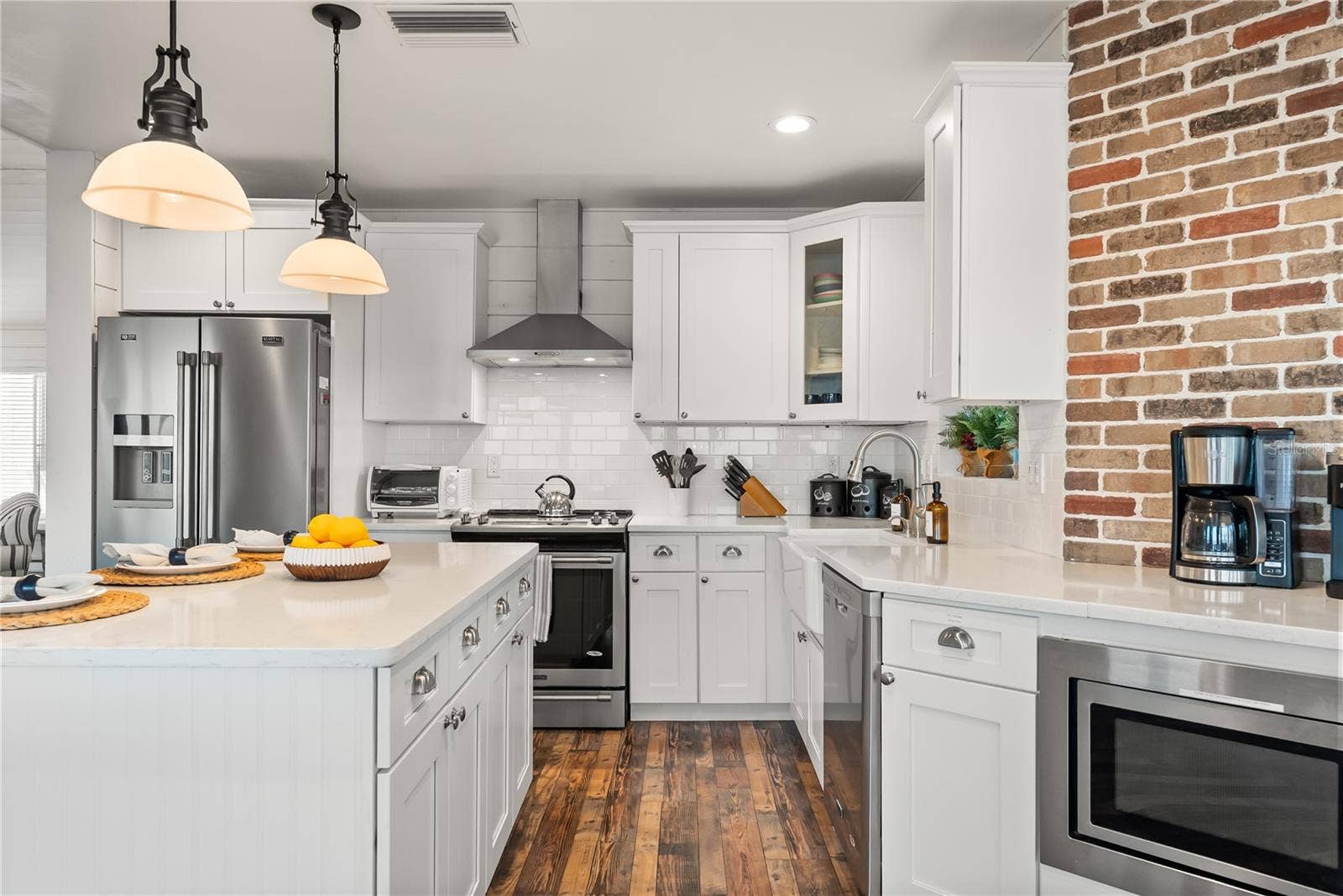 Spacious eat-in kitchen with stainless steel appliances, quartz countertops, breakfast bar seating, and beautiful ocean viewsan inviting setting for casual meals and gathering.