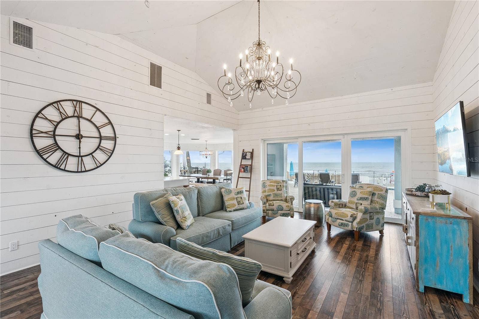 Sweeping Atlantic views take center stage in this bright family room, complemented by coastal furnishings and luxury vinyl plank flooring.