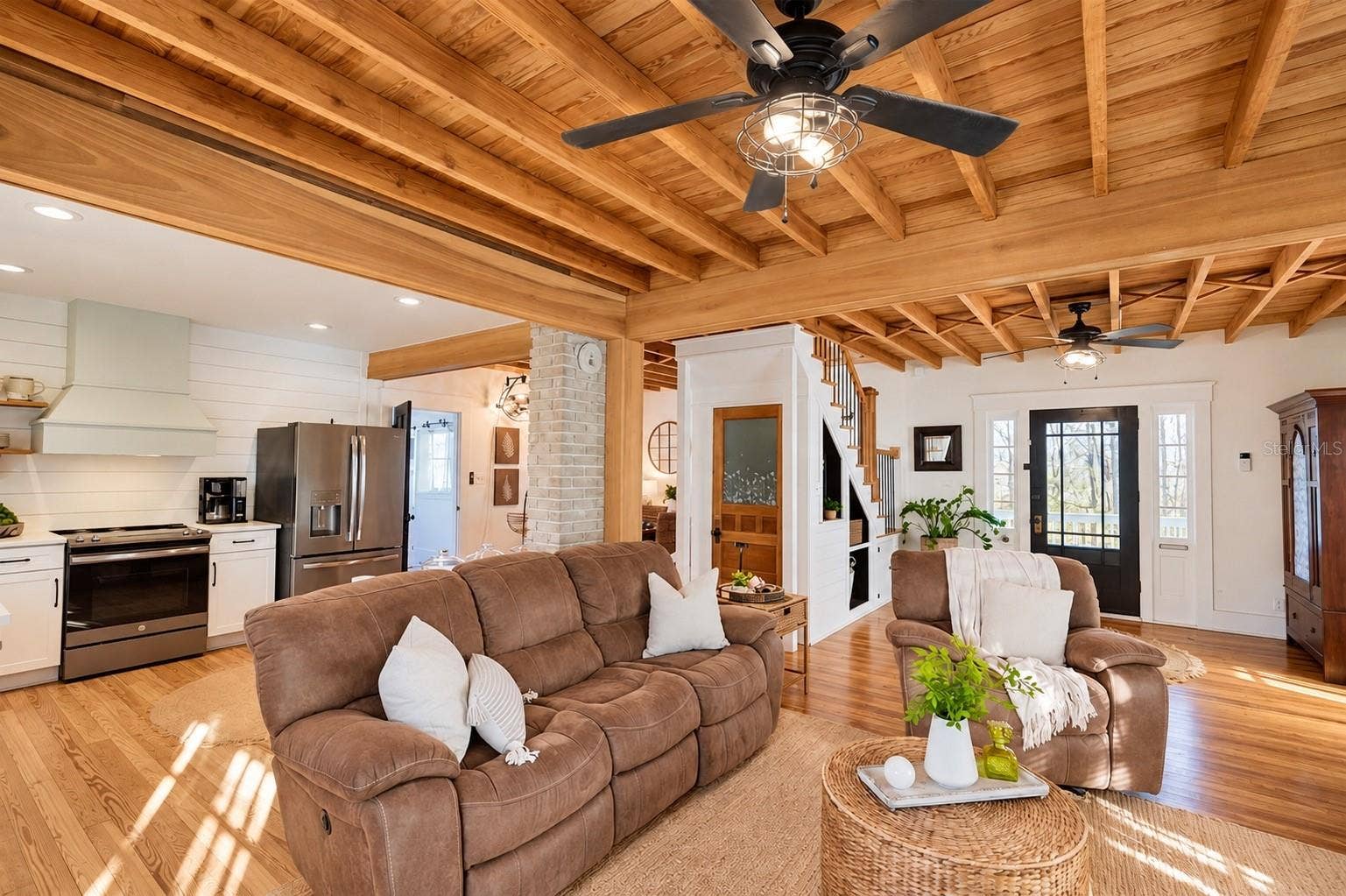 1901 10TH STREET, St Cloud, FL 34769 Beautiful OPEN-CONCEPT living area featuring stunning EXPOSED WOOD BEAM CEILINGS, gorgeous wood flooring, charming shiplap accents, and a seamless flow into the kitchen.