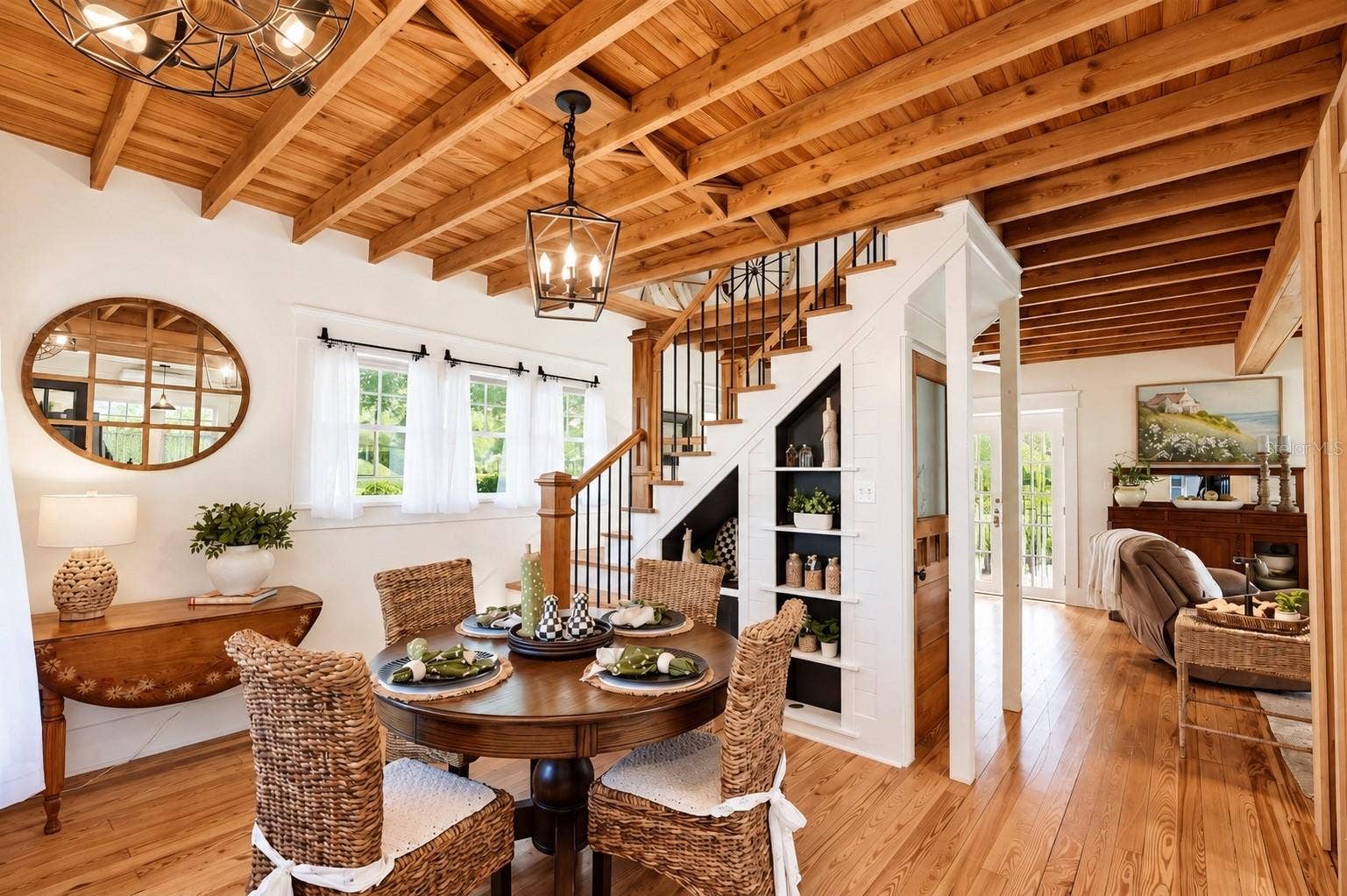 1901 10TH STREET, St Cloud, FL 34769 DINING AREA featuring stunning EXPOSED WOOD BEAM CEILINGS, beautiful WOOD FLOORING, stylish pendant lighting, and CUSTOM BUILT-IN SHELVING beneath the staircase.